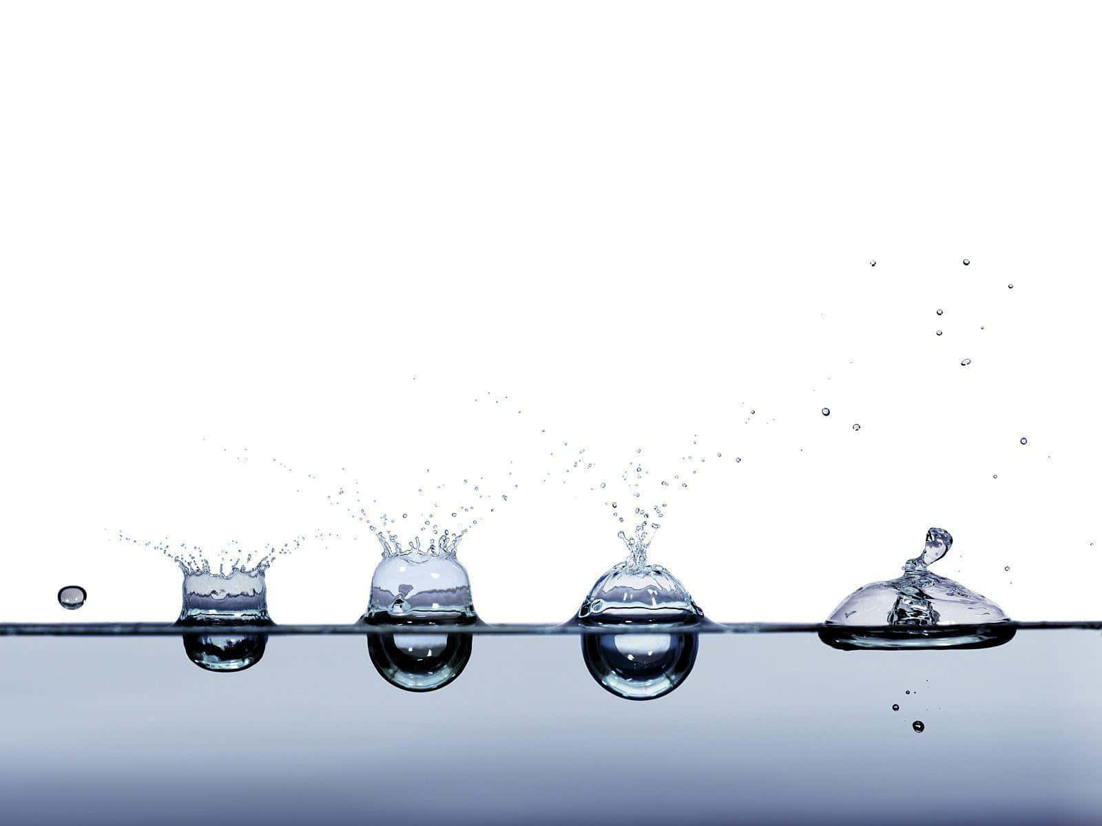 motion 桌布 壁紙 — 四滴完美定時的水滴在純白背景上形成對稱的水花。