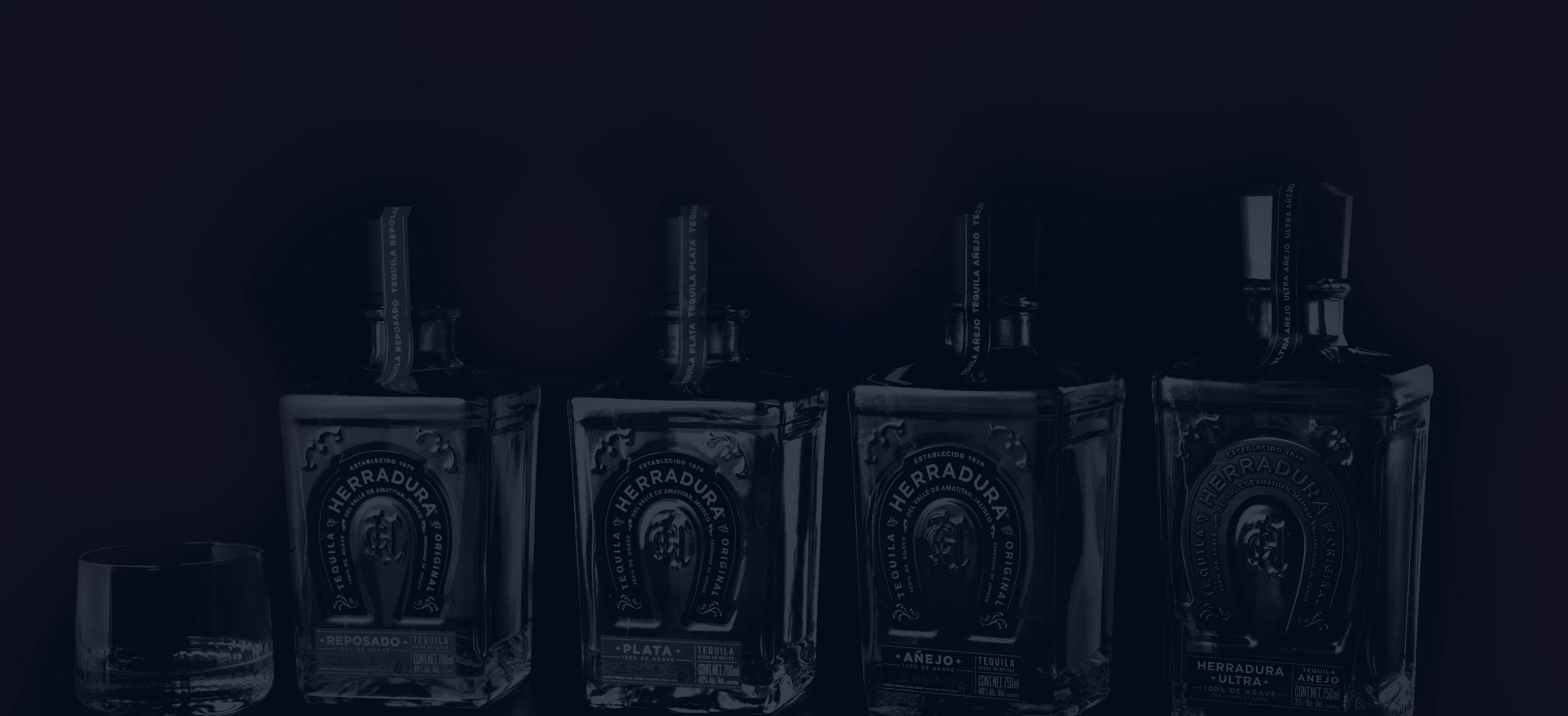 高清 桌布 壁紙 — 四瓶深色 Herradura 龍舌蘭酒和一個玻璃架，在黑色背景的陰影寂靜中。