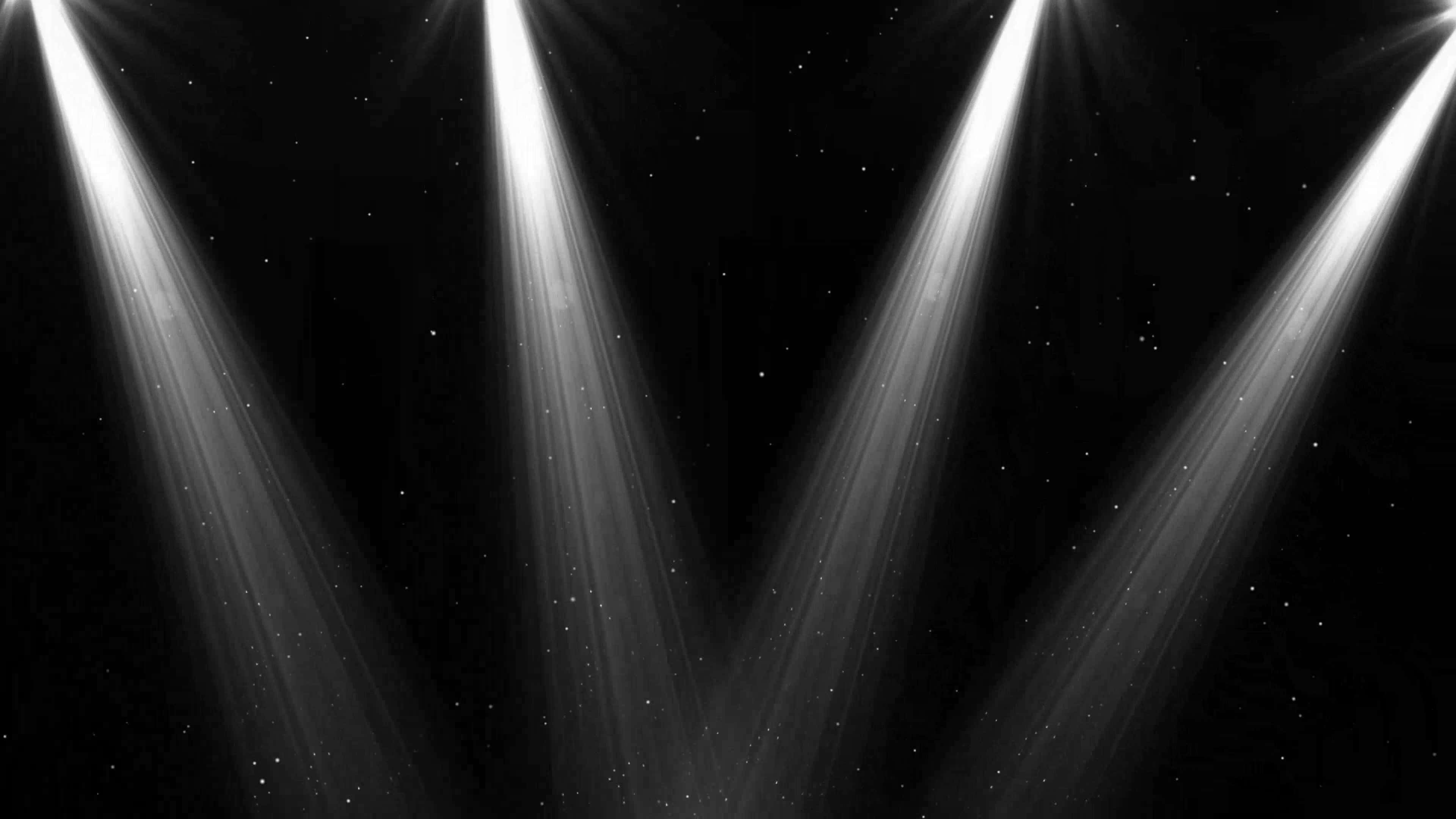 Spotlight 桌布 壁紙 — 四盞明亮的聚光燈從上方照射下來，映襯著點綴著小星星的黑暗背景。