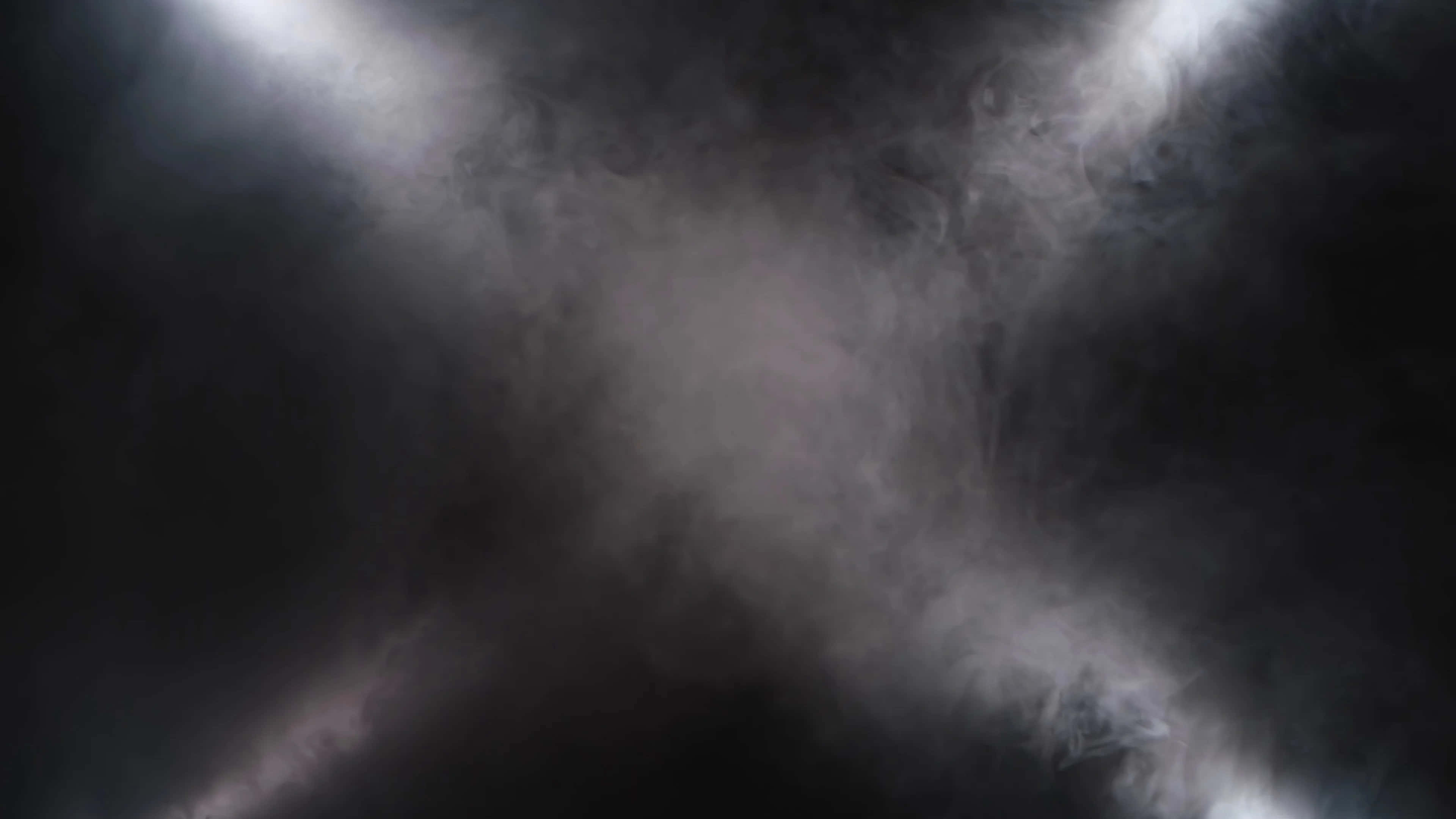 Smoky 桌布 壁紙 — 四盞明亮的聚光燈穿透旋轉的黑暗煙霧，營造出戲劇性的舞台效果。