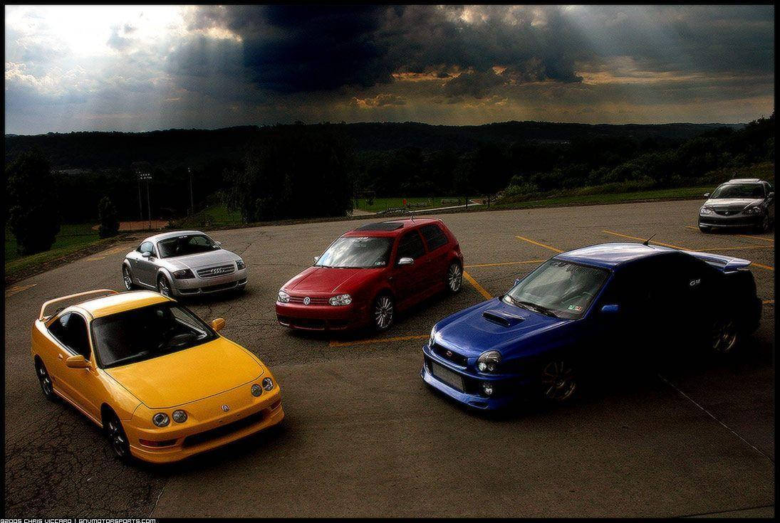 JDM 桌布 壁紙 — 四輛充滿活力的改裝車停在停車場，背景是戲劇性的暴風雲和穿透的陽光。
