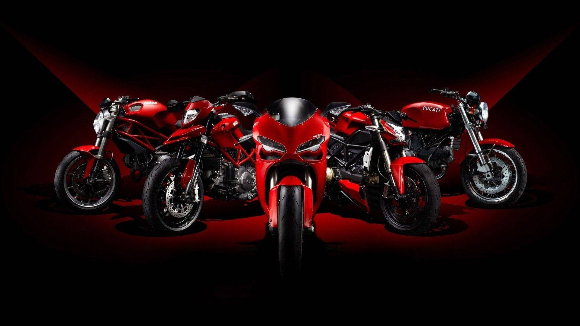 motorbike 桌布 壁紙 — 四輛時尚的紅色Ducati摩托車在黑暗背景中，以紅色聚光燈戲劇性地照亮。