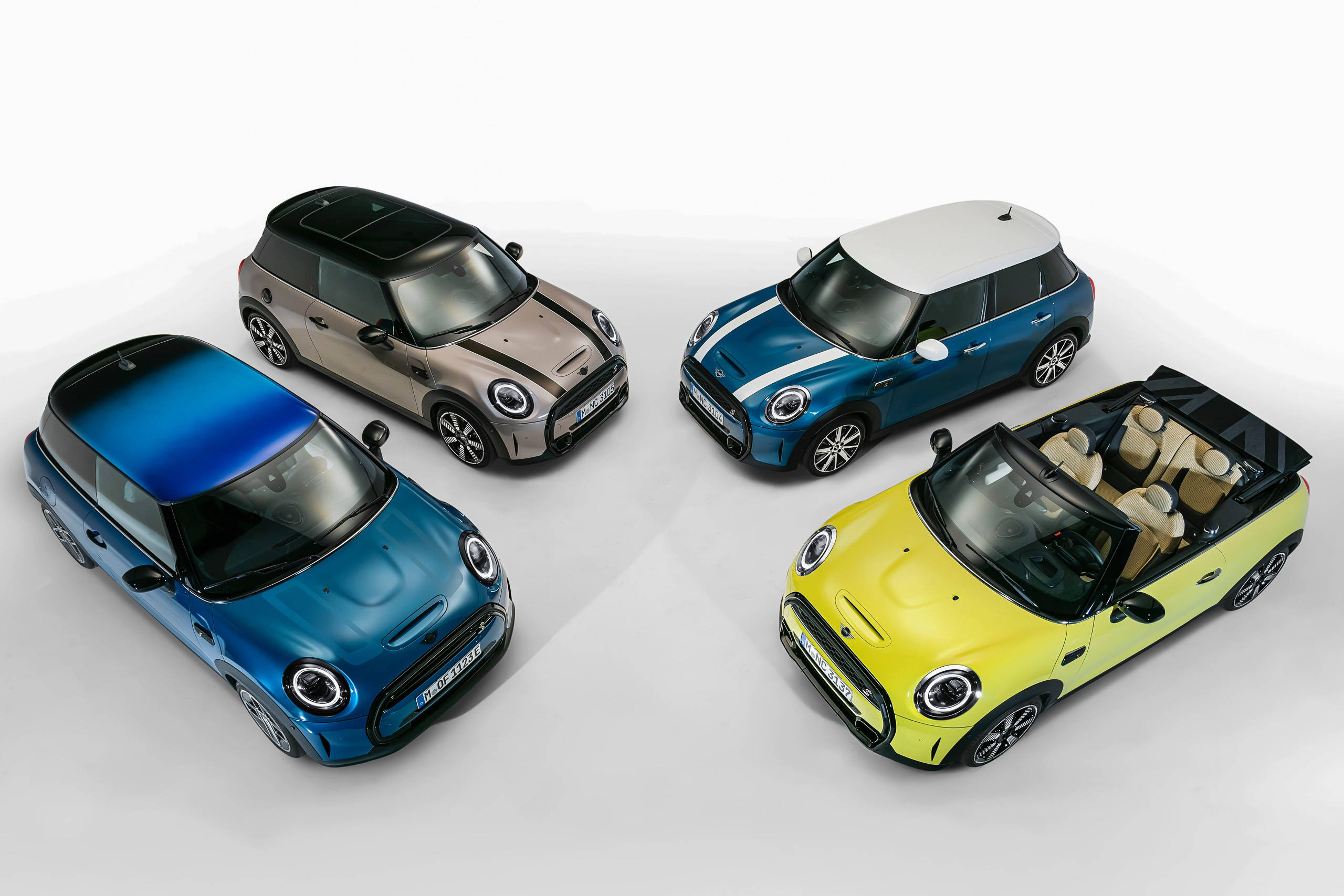 彩色動圖 桌布 壁紙 — 四輛色彩鮮豔的MINI Cooper汽車，分別為藍色、灰色、黃色及雙色藍白，在潔淨的攝影棚環境中展示。