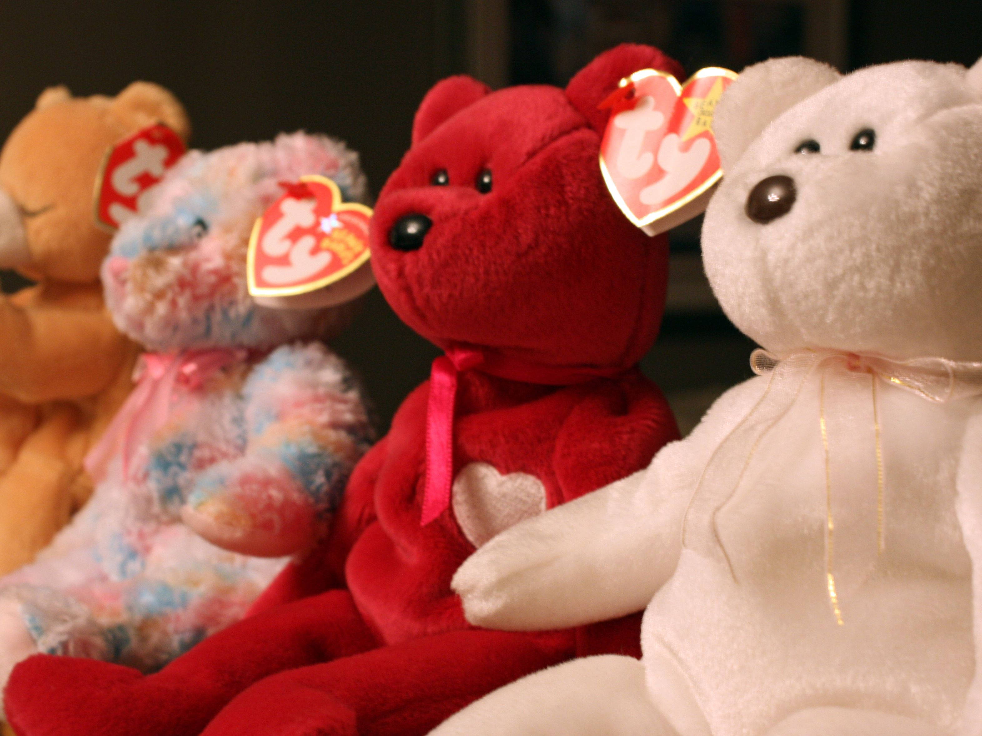 Beanie 桌布 壁紙 — 四隻紅色、橙色、粉彩和白色的 Ty Beanie Babies 毛絨熊緊密地坐在一起，心形標籤清晰可見。