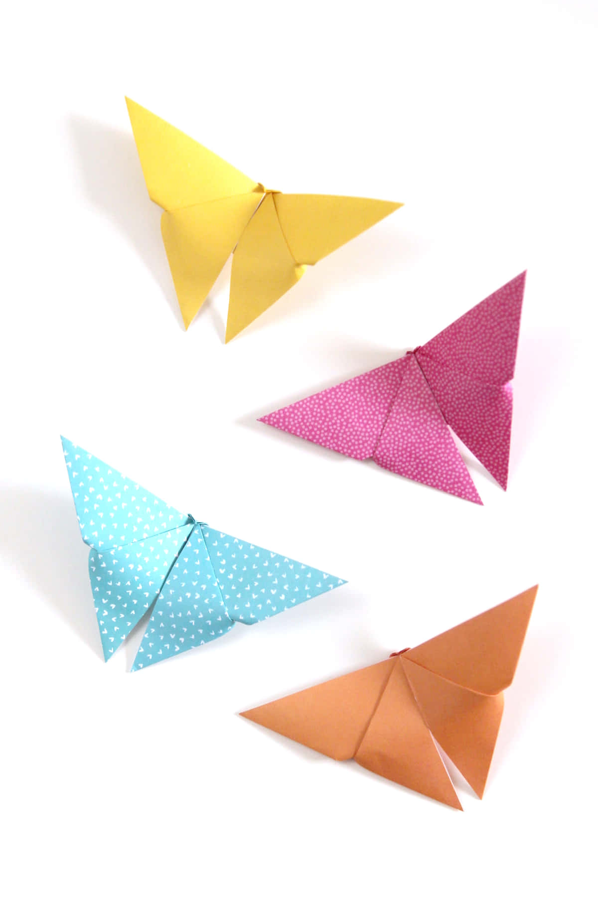 Butterfly Origami 桌布 壁紙 — 四隻色彩繽紛的摺紙蝴蝶，翅膀帶有圖案，漂浮在純白背景上。