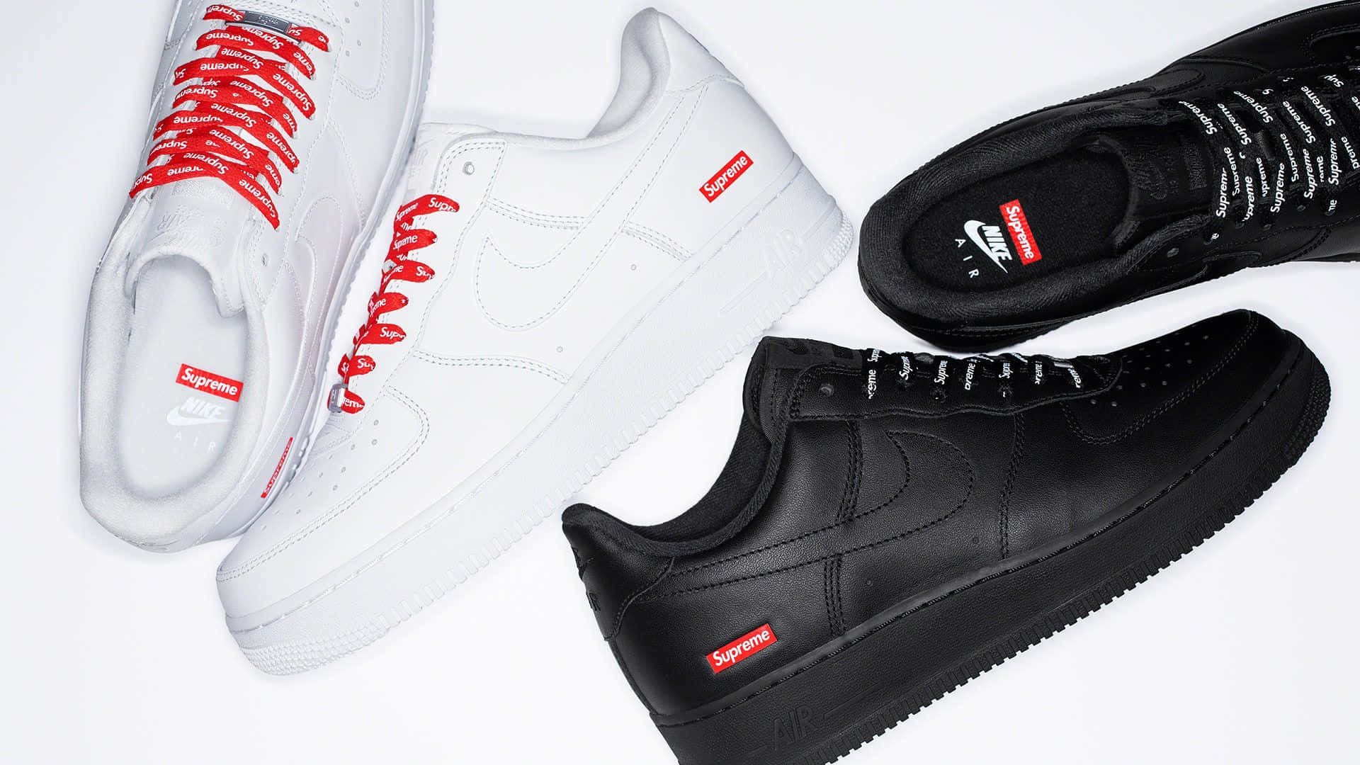 桌布 壁紙 — 四雙白色和黑色的Supreme x Nike Air Force 1運動鞋，帶有紅色品牌標誌，整齊排列在潔白背景上。
