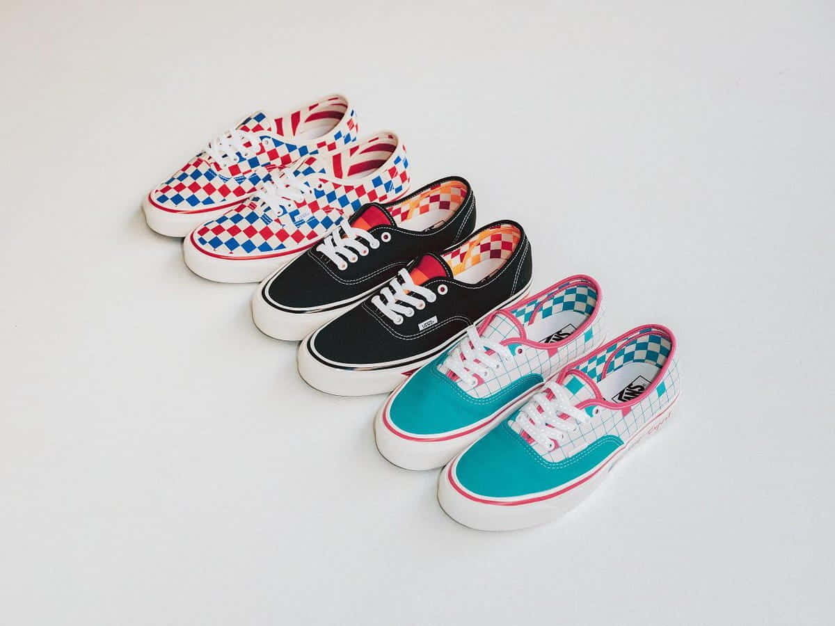 Vans 桌布 壁紙 — 四雙色彩繽紛的Vans運動鞋，帶有格紋和純色圖案，在純白色背景上對角排列。