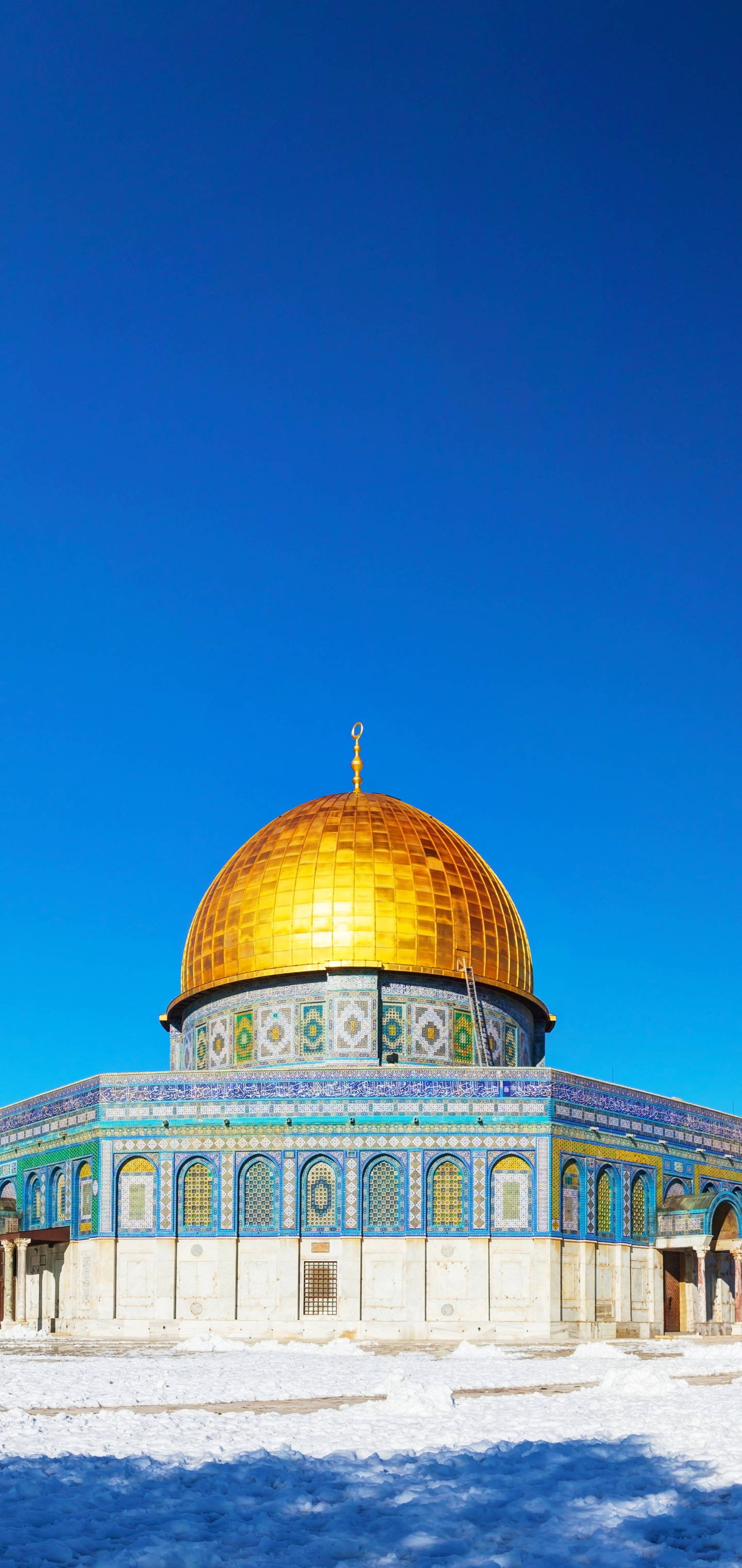 muslim 桌布 壁紙 — 圓頂清真寺在晴朗的藍天下閃耀著金色光芒，地面覆蓋著白雪。