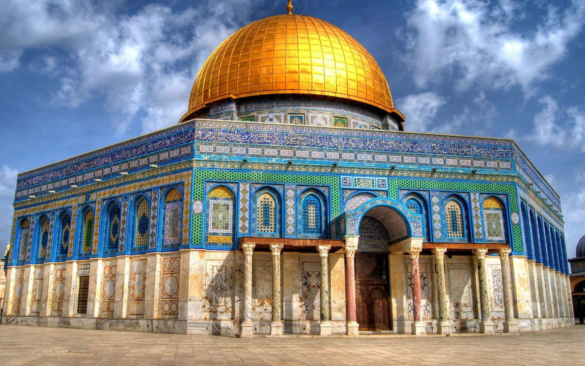 Israel 桌布 壁紙 — 圓頂清真寺在晴朗藍天和 fluffy 白雲下閃耀金光，其精緻的藍綠瓷磚外牆細節生動發光。