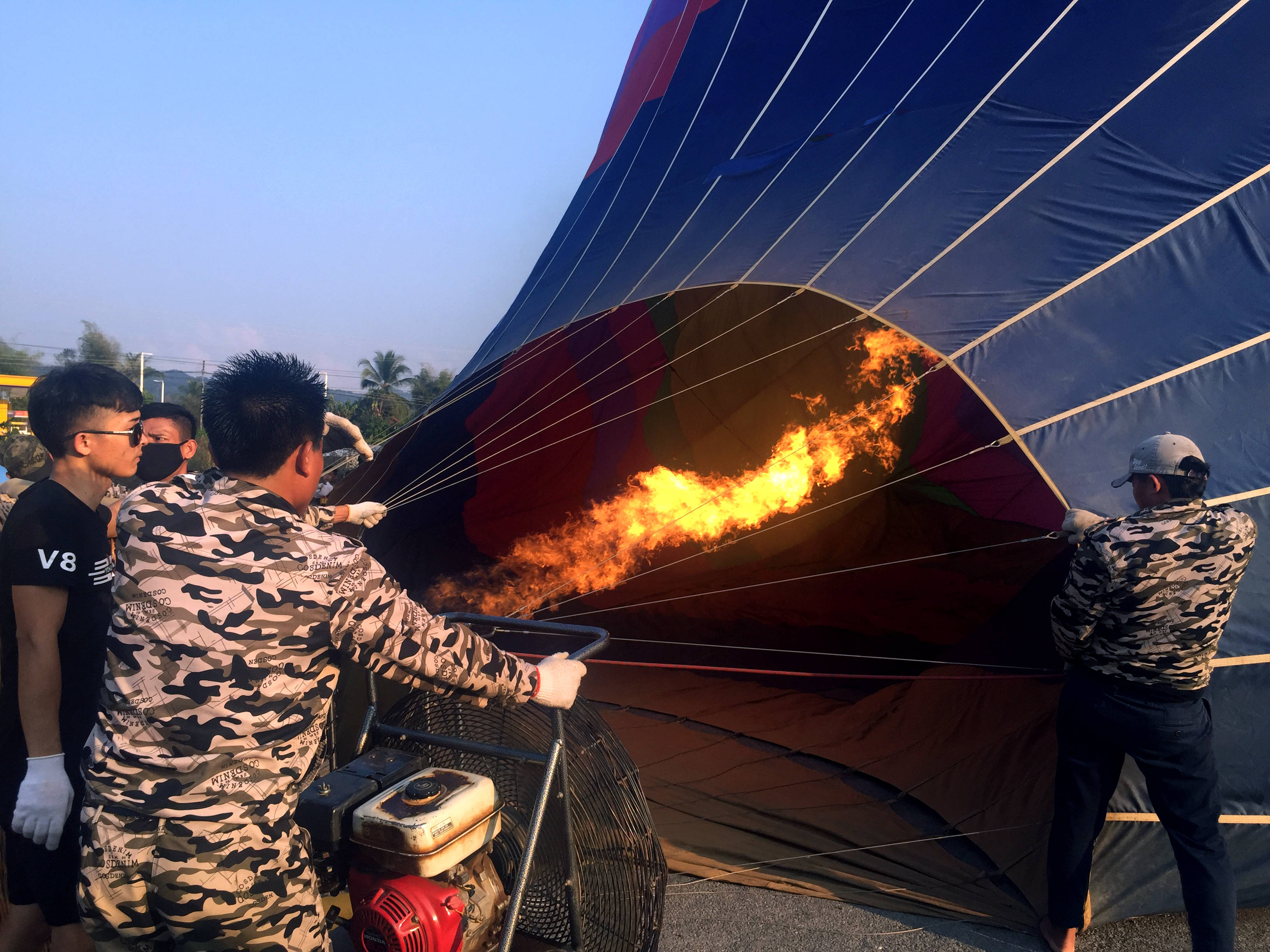 Laos 桌布 壁紙 — 團隊成員在清晨準備期間用燃燒器點燃一個大型藍色熱氣球。
