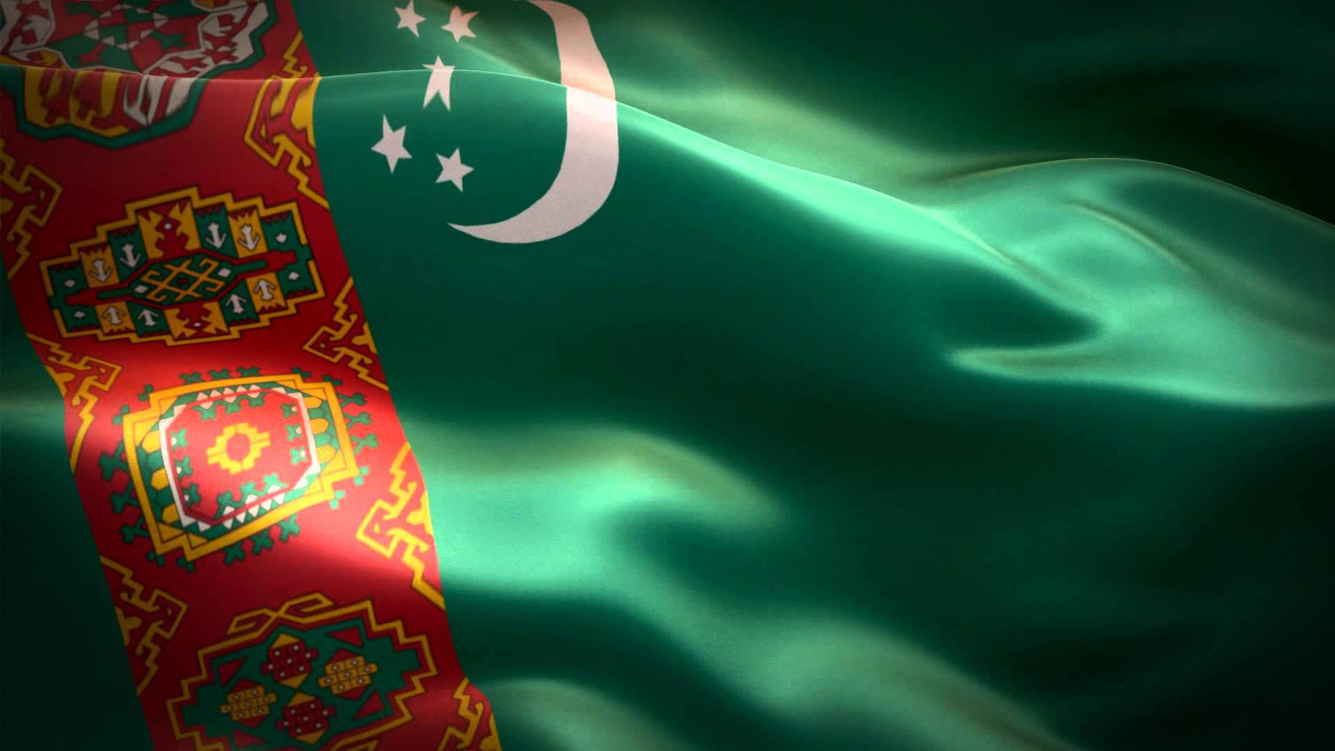 Turkmenistan 桌布 壁紙 — 土庫曼斯坦國旗在柔和光線下動態飄揚，帶有豐富的綠色、紅色和金色圖案。