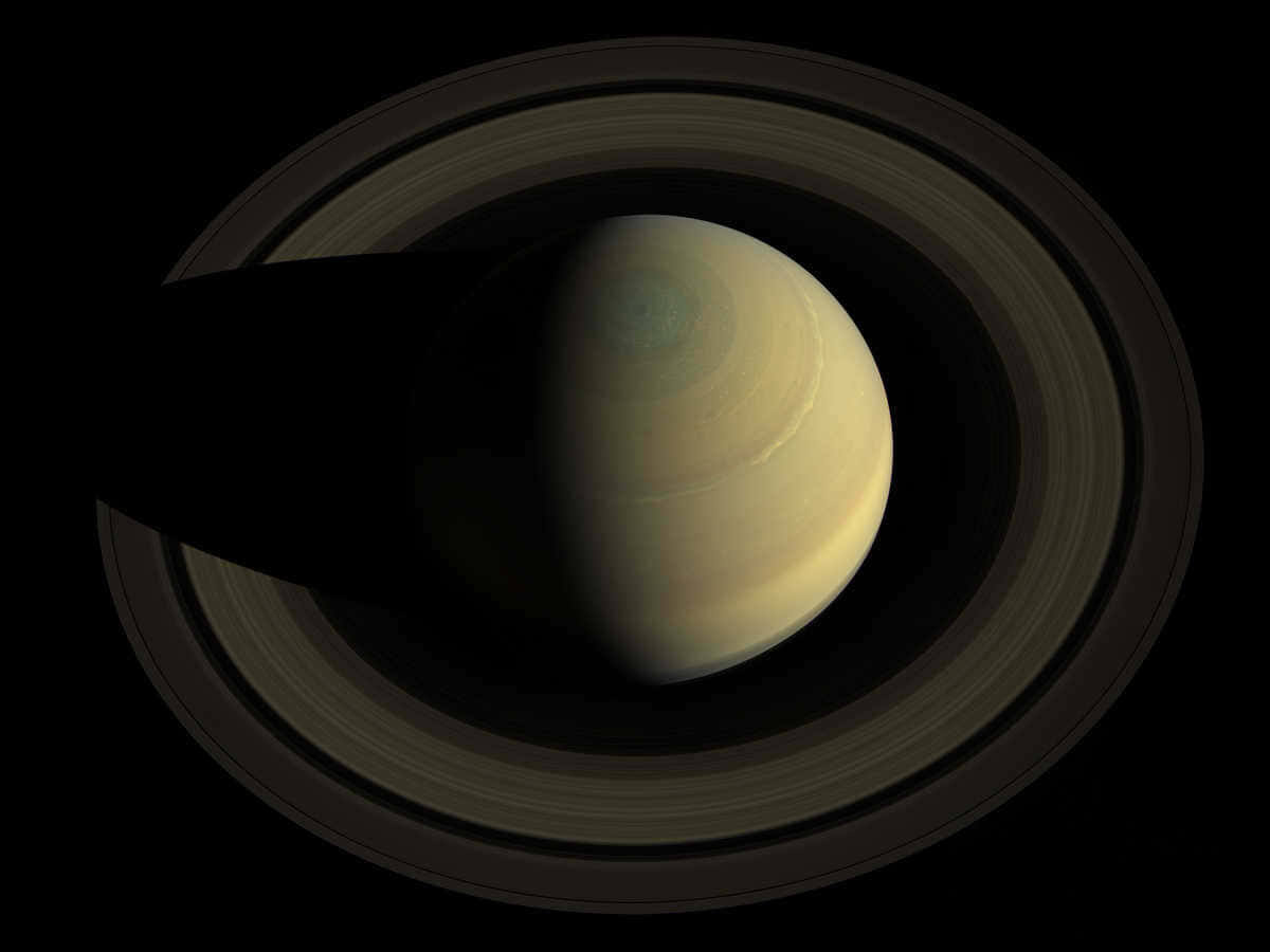 土星 桌布 壁紙 — 土星在虛空中柔和地發光，其標誌性的環在其表面投下長長的陰影。