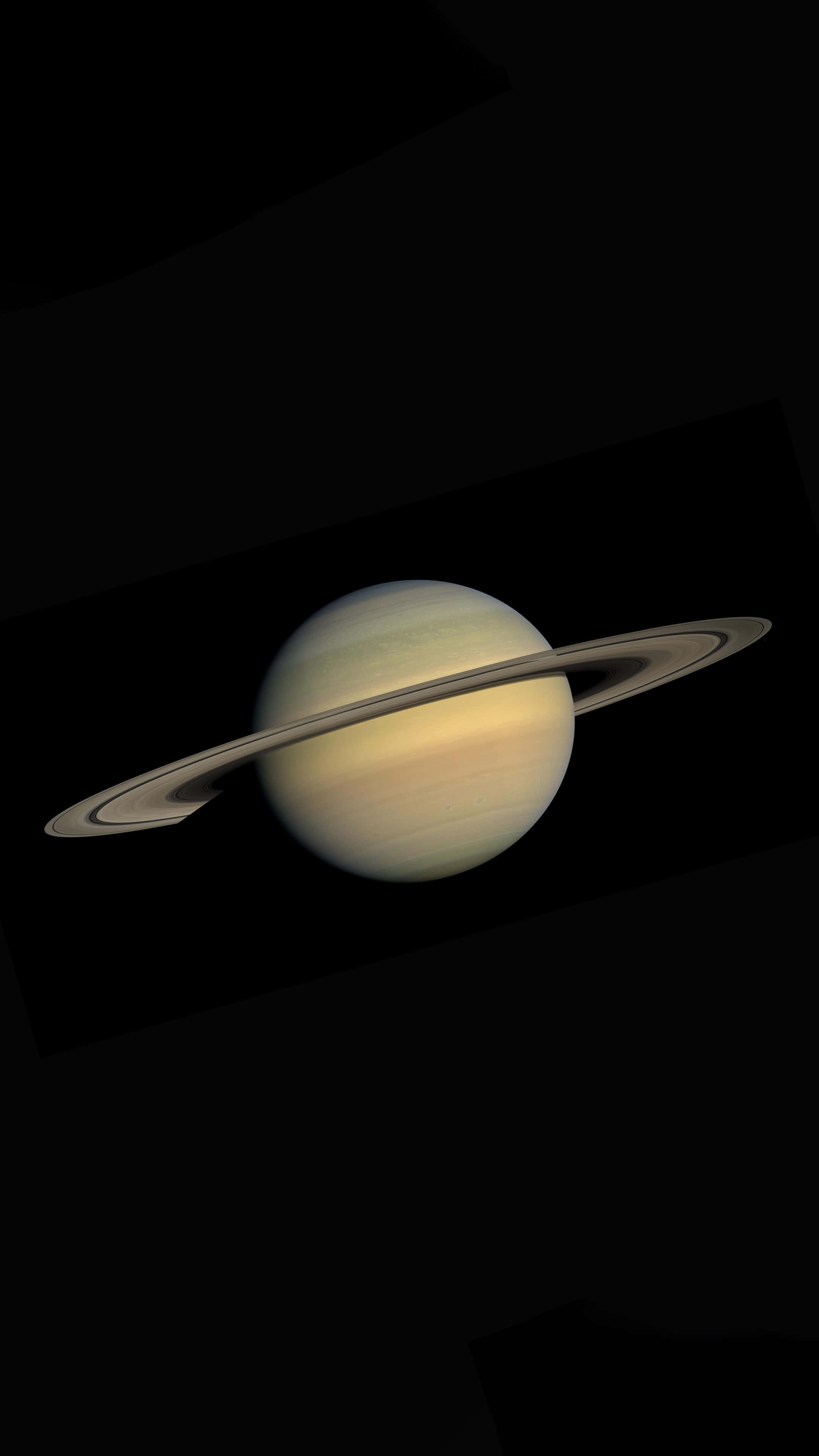 土星 桌布 壁紙 — 土星在虛空中柔和發光，其標誌性光環在深空中投下精緻的陰影。