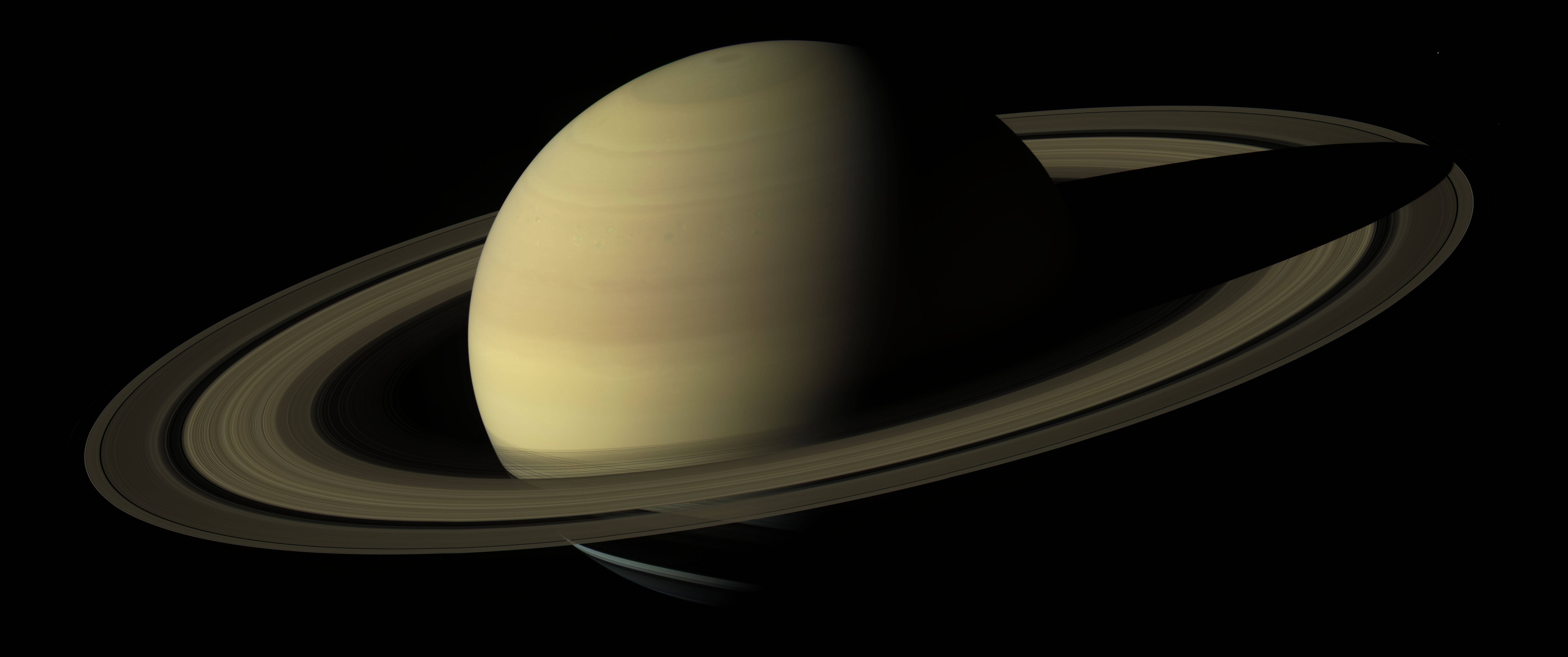 土星 桌布 壁紙 — 土星在虛空中柔和發光，其標誌性環在深空中投下銳利陰影。