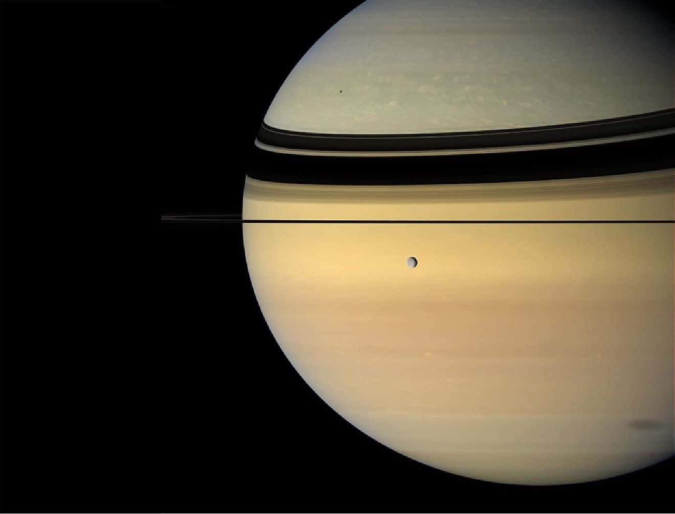 土星 桌布 壁紙 — 土星標誌性光環和淡黃色大氣層在黑色太空虛空中的特寫。
