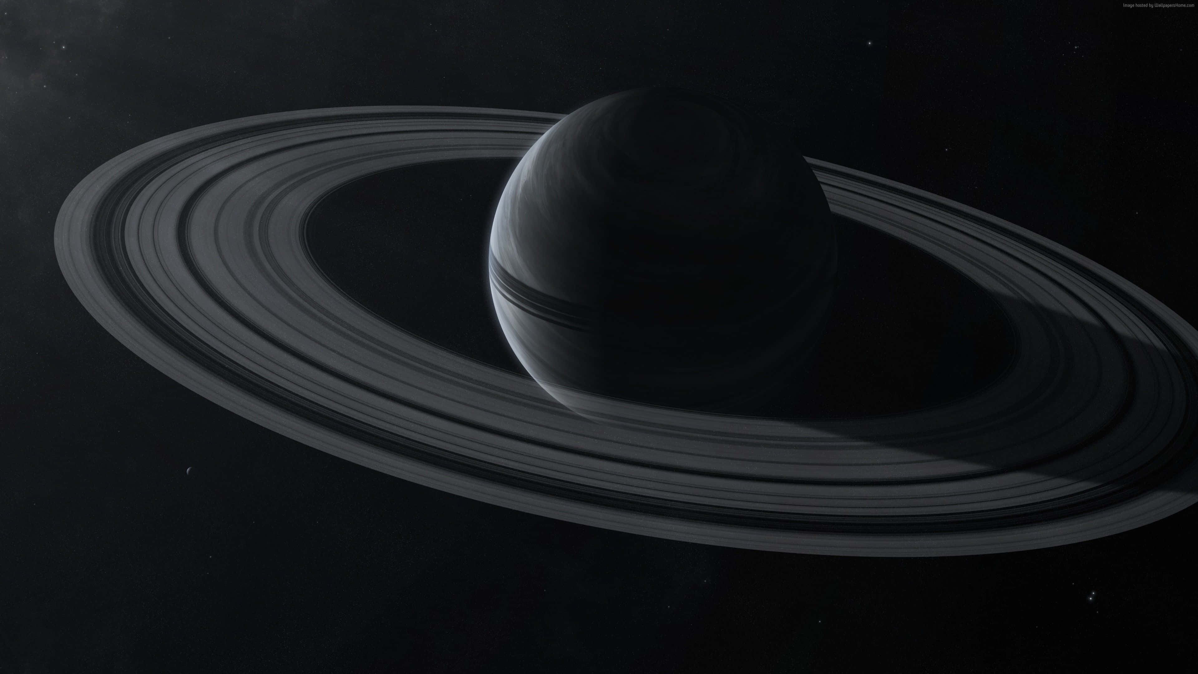 Exoplanet 桌布 壁紙 — 土星的單色視圖，其標誌性光環在太空的虛空中柔和發光。