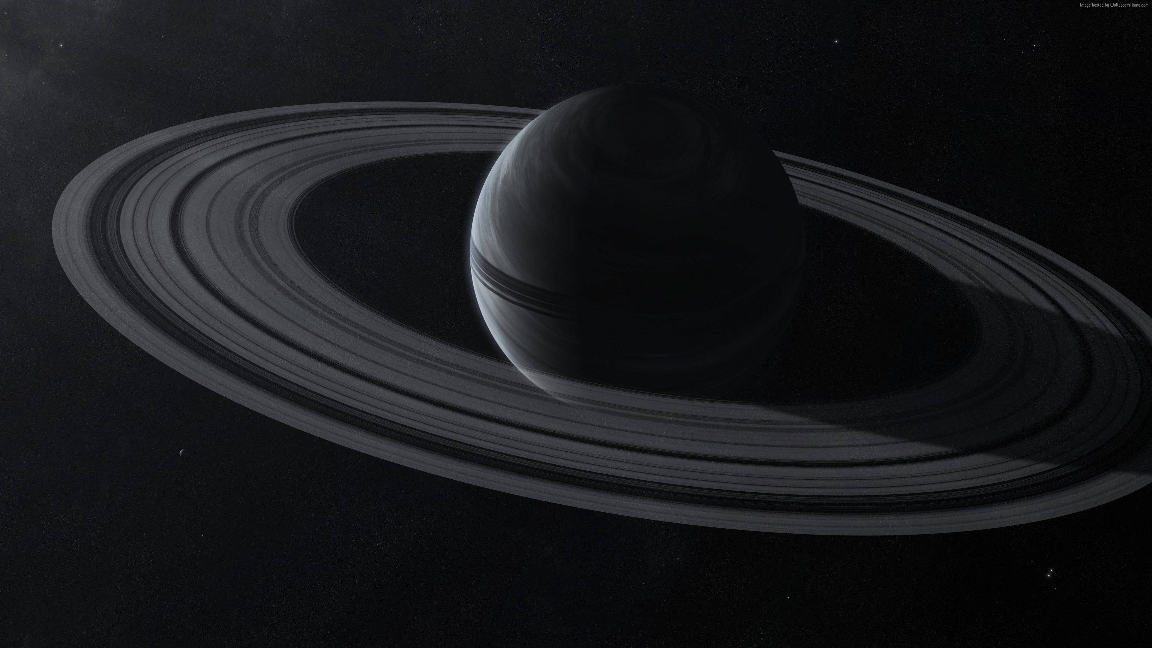 Black Planet 桌布 壁紙 — 土星的單色視圖，其標誌性光環在太空虛空中柔和發光。