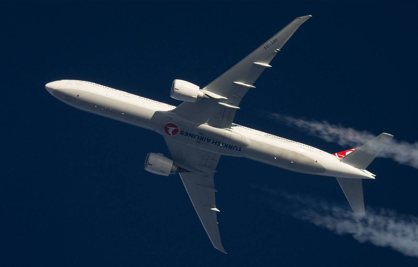 飛機 桌布 壁紙 — 土耳其航空波音777在深藍色天空中翱翔，留下白色凝結尾跡。