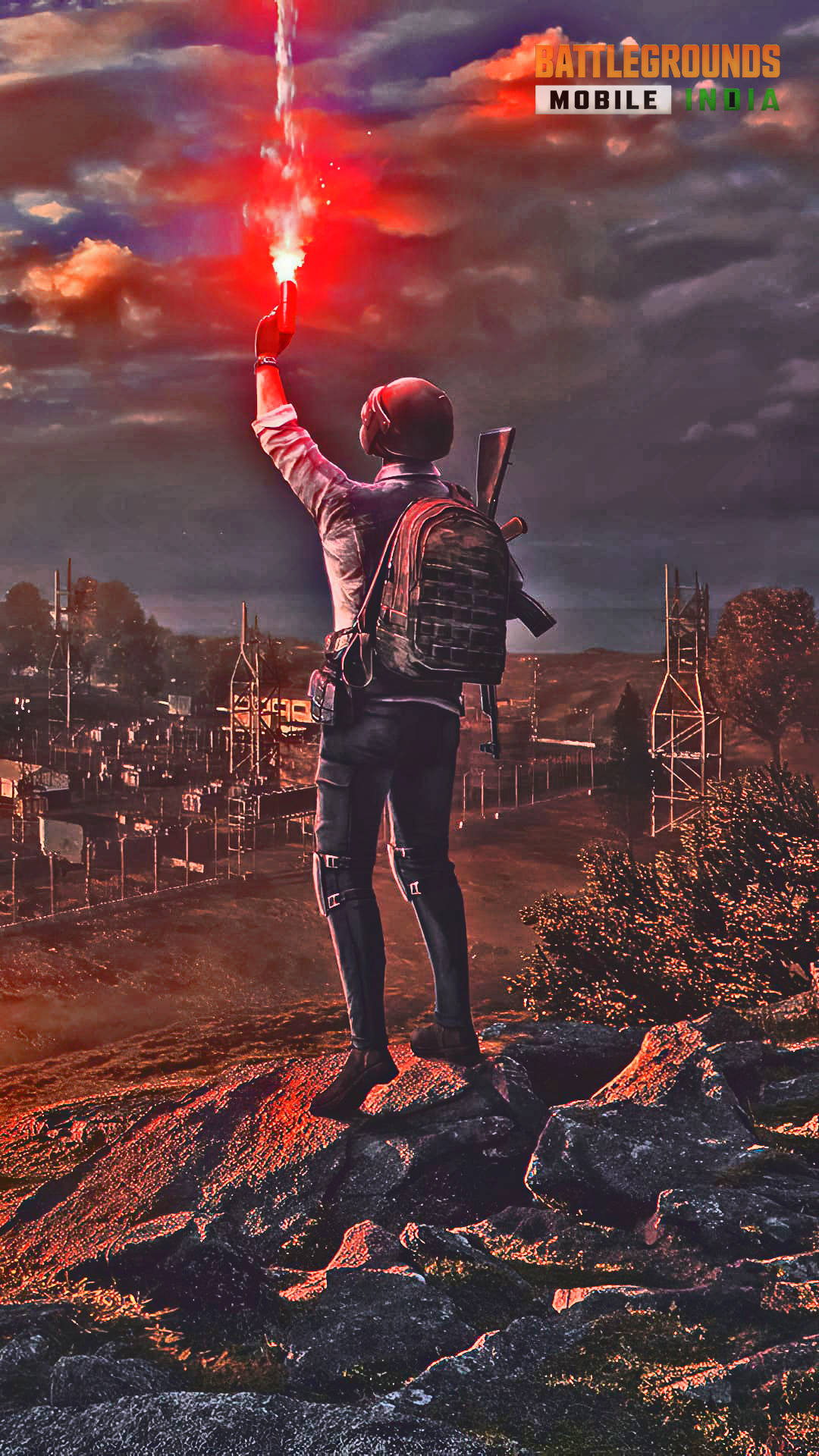 電玩遊戲 桌布 壁紙 — 在 Battlegrounds Mobile India 中，一名玩家在黃昏時站在岩石山上，向廢墟城市上空火紅的天空發射信號彈。