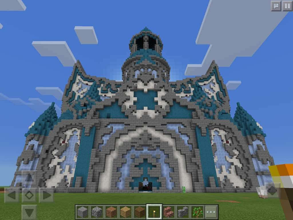 Minecraft Bedrock Edition 桌布 壁紙 — 在 Minecraft 中，一座由青綠色和灰色方塊組成的巨大像素城堡，矗立在晴朗的藍天下。