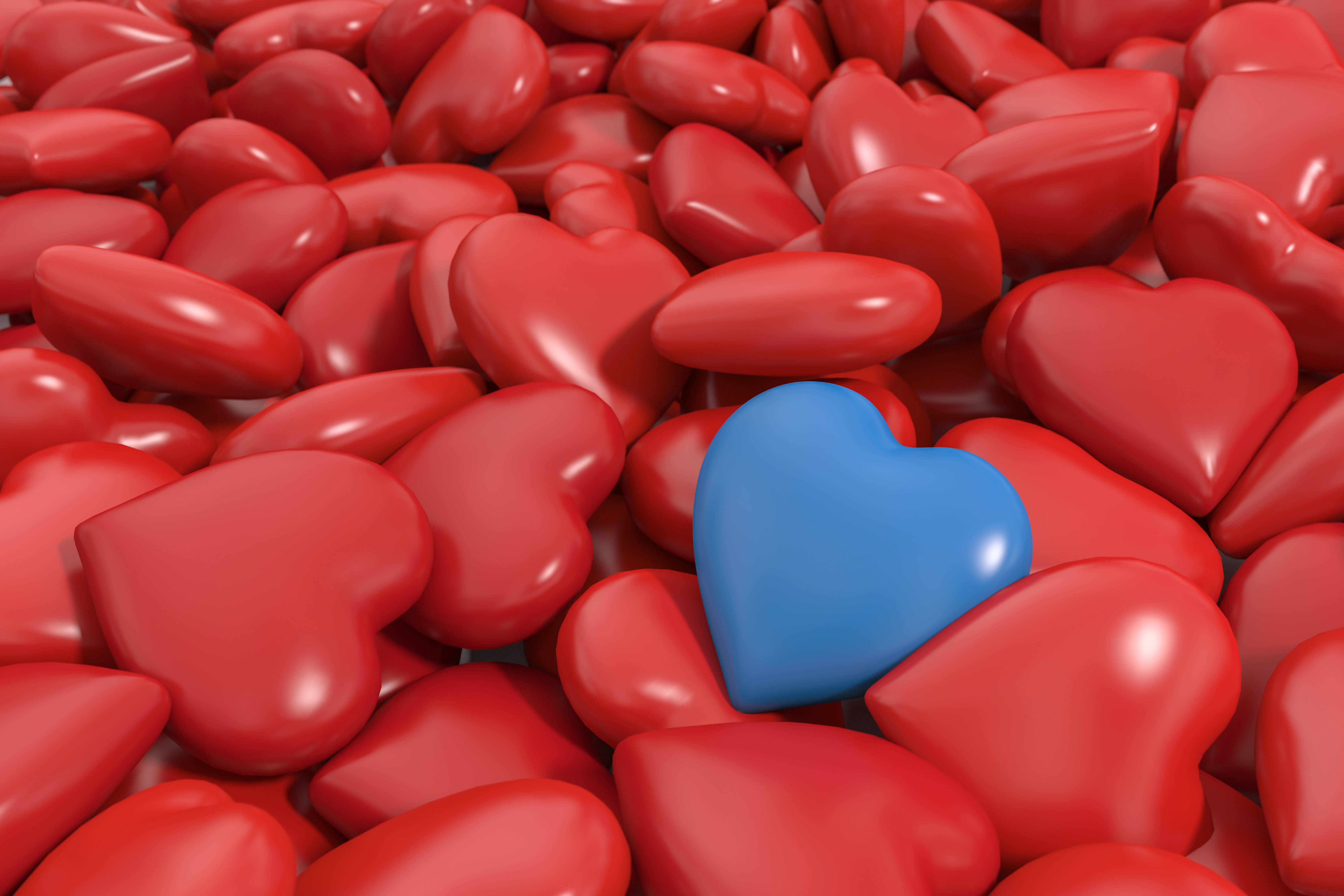 Blue Heart 桌布 壁紙 — 在3D渲染的場景中，一顆藍色心臟在一片閃亮的紅色心臟中脫穎而出。