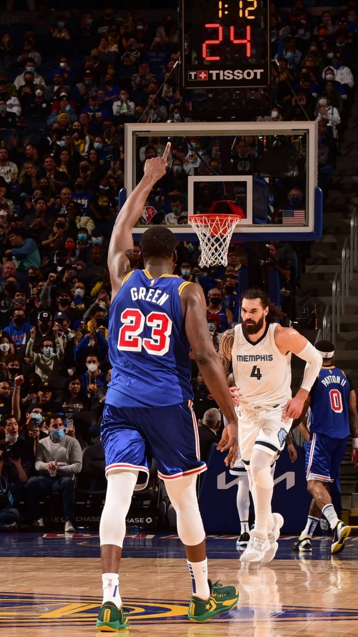Draymond Green 桌布 壁紙 — 在一場座無虛席的球場比賽中，身穿藍色23號球衣的籃球運動員在身穿白色4號球衣的曼菲斯灰熊隊球員防守下投出跳投。