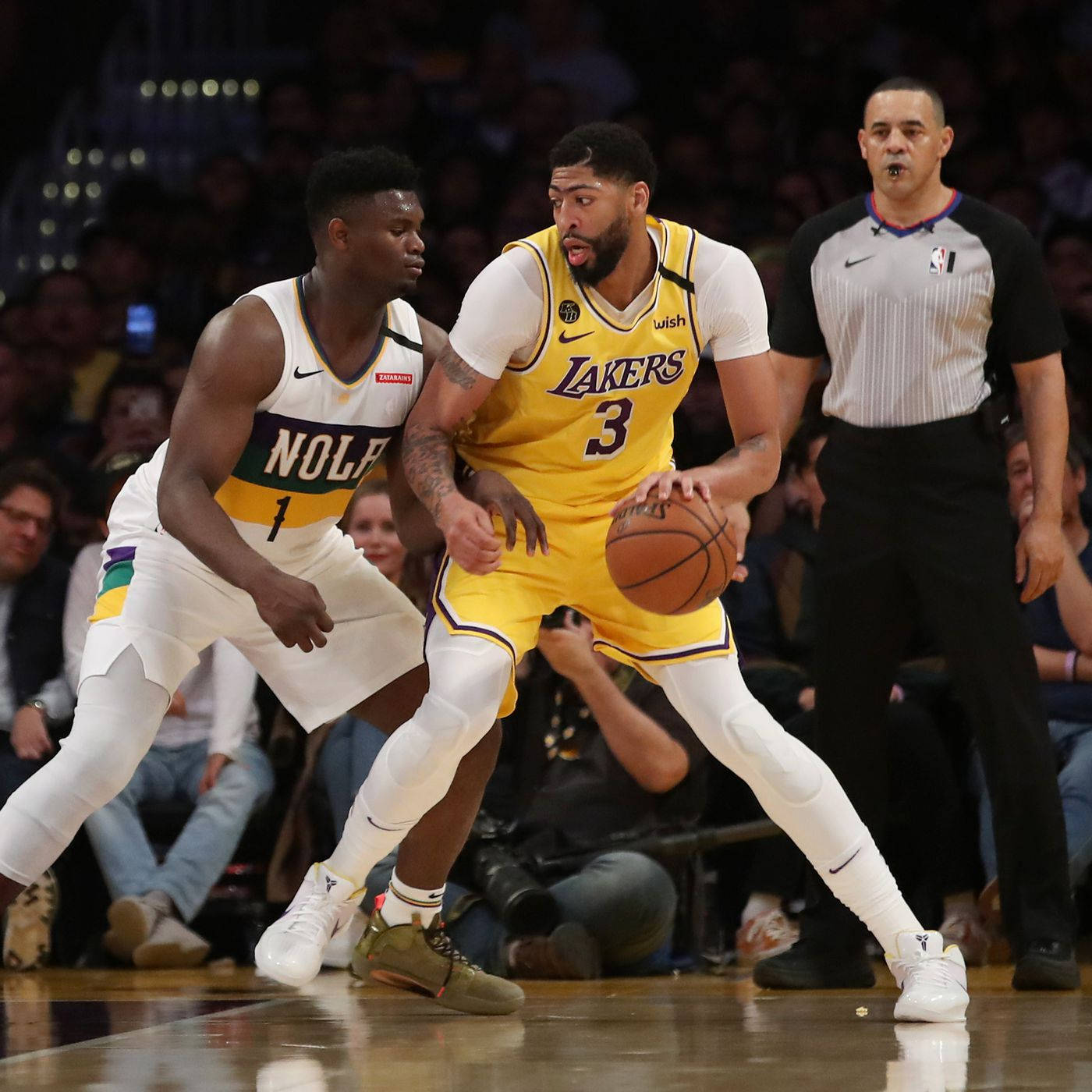 NBA 桌布 壁紙 — 在一場激烈的NBA比賽中，一位身穿黃色球衣的湖人球員運球，同時被紐奧良鵜鶘的防守球員緊密防守。