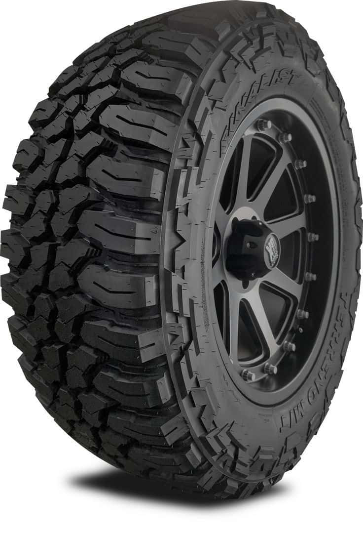 Winter Tires 桌布 壁紙 — 在乾淨的白色背景上，一個堅固的黑色全地形輪胎安裝在霧面黑色多輻輪圈上的特寫攝影棚照片。