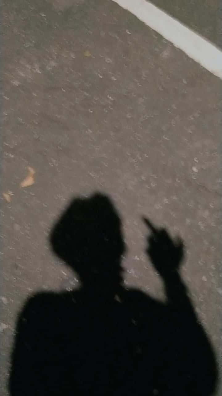 shadow 桌布 壁紙 — 在低光下，一個人在有紋理的路面上舉起手指的鮮明黑色陰影。