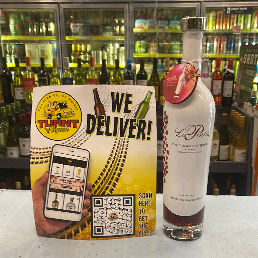 bottle 桌布 壁紙 — 在光線充足的酒類專賣店中，一瓶 La Pinta 石榴利口酒旁邊放著一張 Turnt Liquor 配送促銷傳單。