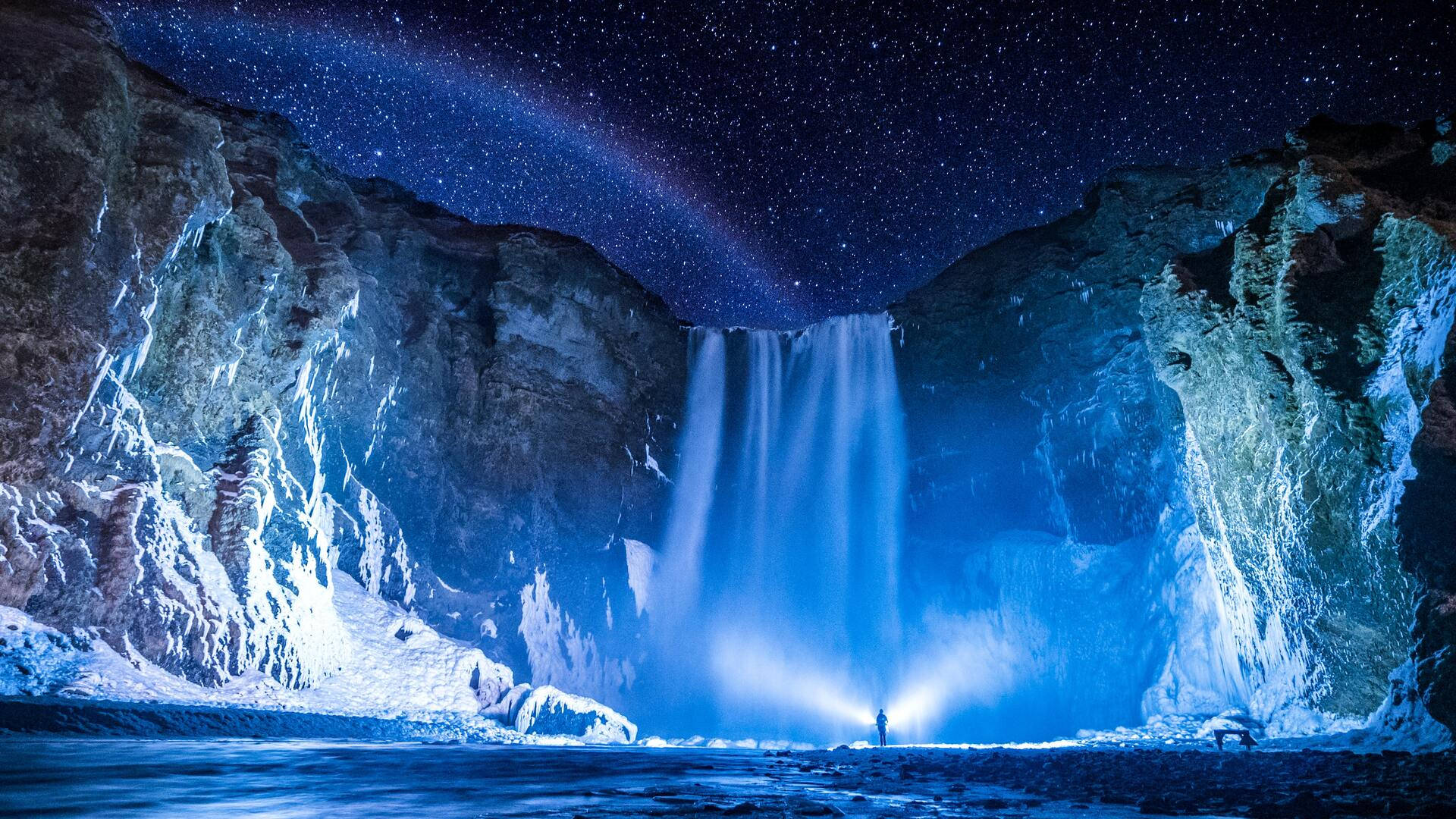 夜晚星空下站在發光瀑布下的人 — 瀑布 GIF 壁紙