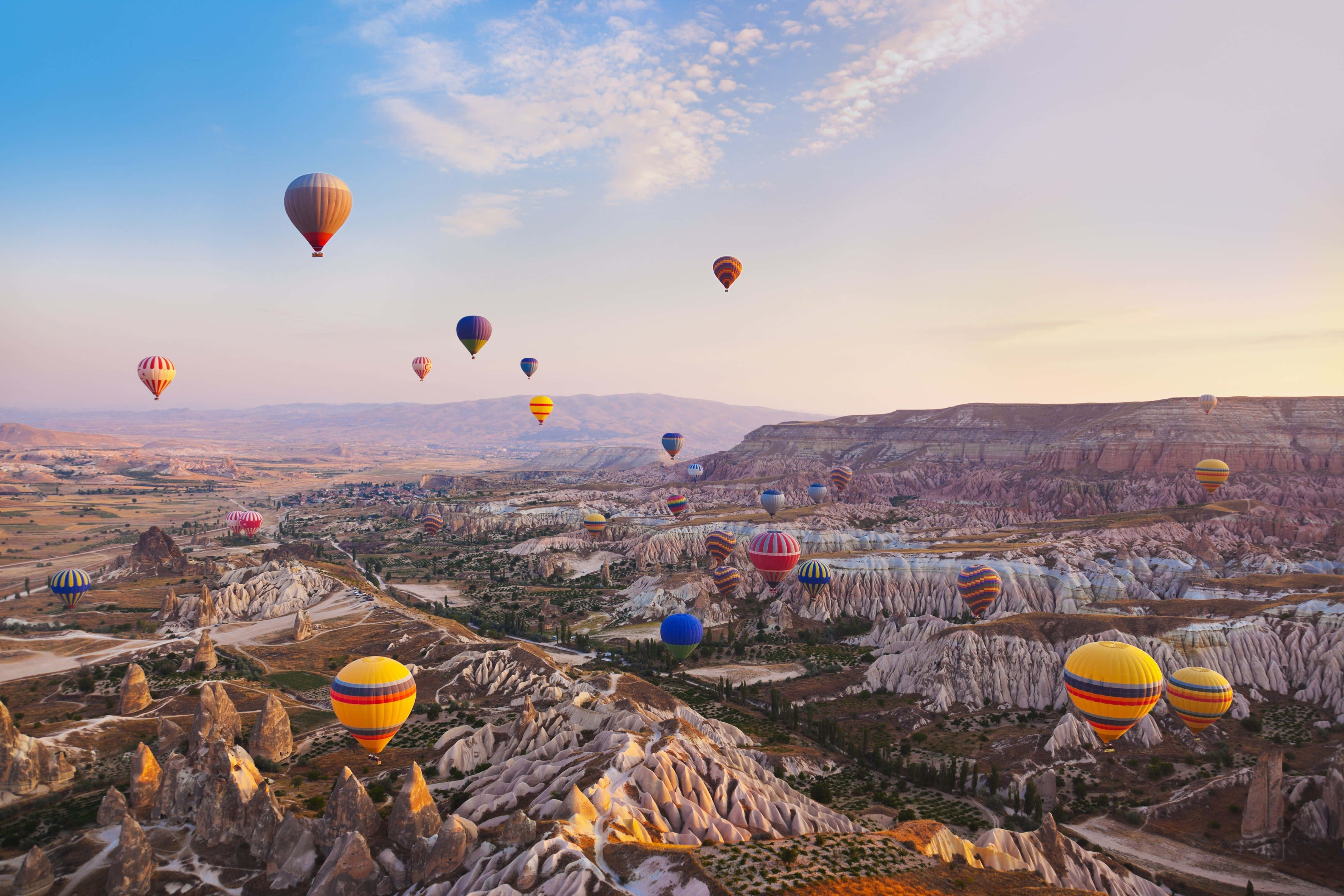 Hot Air Balloon 桌布 壁紙 — 在卡帕多奇亞的日出時分，色彩繽紛的熱氣球在超現實的岩石地貌上飄浮。