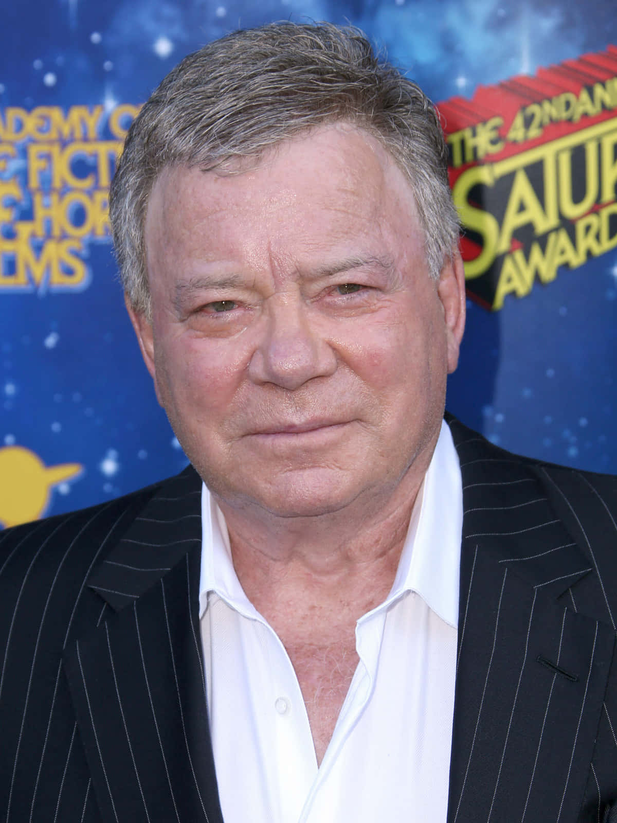 william shatner 桌布 壁紙 — 在土星獎活動中，一位灰白頭髮男士穿著黑色細條紋西裝和白色襯衫的特寫肖像。