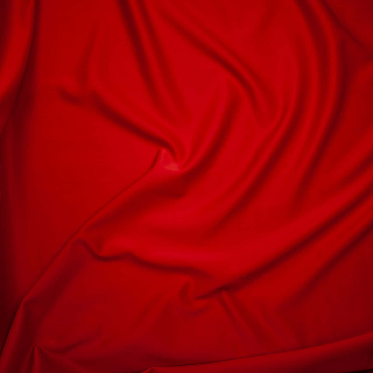 Solid Red 桌布 壁紙 — 在均勻光線下，帶有流動皺褶和柔和亮點的豐富深紅色緞面布料。