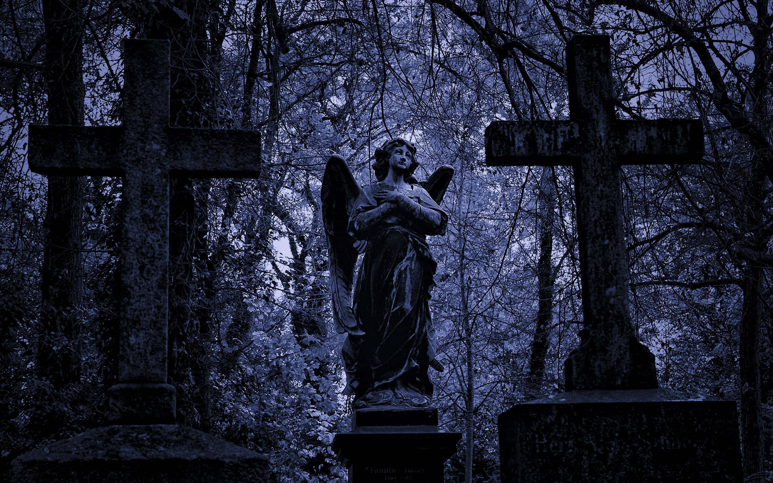 Graveyard 桌布 壁紙 — 在夜晚霧氣瀰漫的藍調墓地中，一座莊嚴的天使雕像矗立在兩個風化的十字架之間。