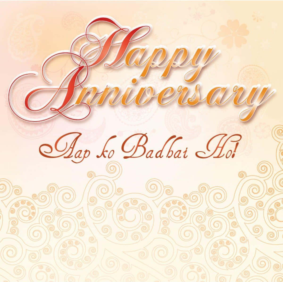 Happy Anniversary 桌布 壁紙 — 在奶油色背景上，以華麗的漩渦圖案襯托，優雅的週年紀念問候，包含草書「Happy Anniversary」和「Aap ko Badhai Ho!」。