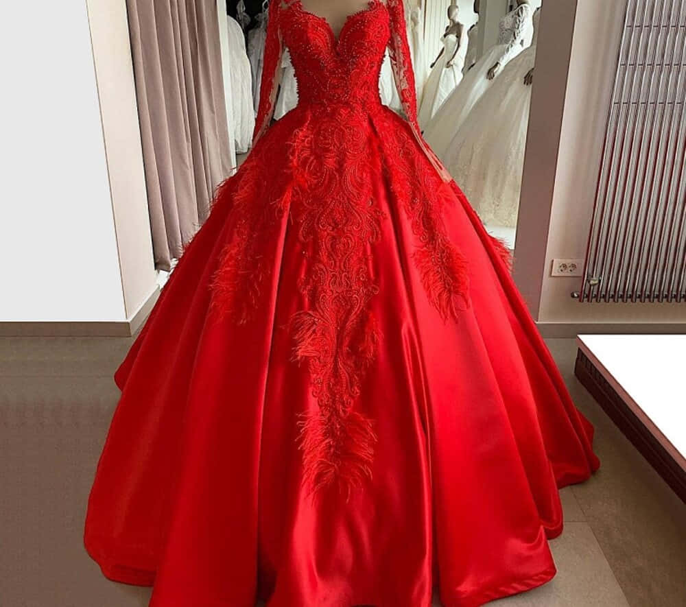 Red Wedding 桌布 壁紙 — 在婚紗店展示的華麗紅色緞面舞會禮服，飾有精緻羽毛刺繡和長袖。