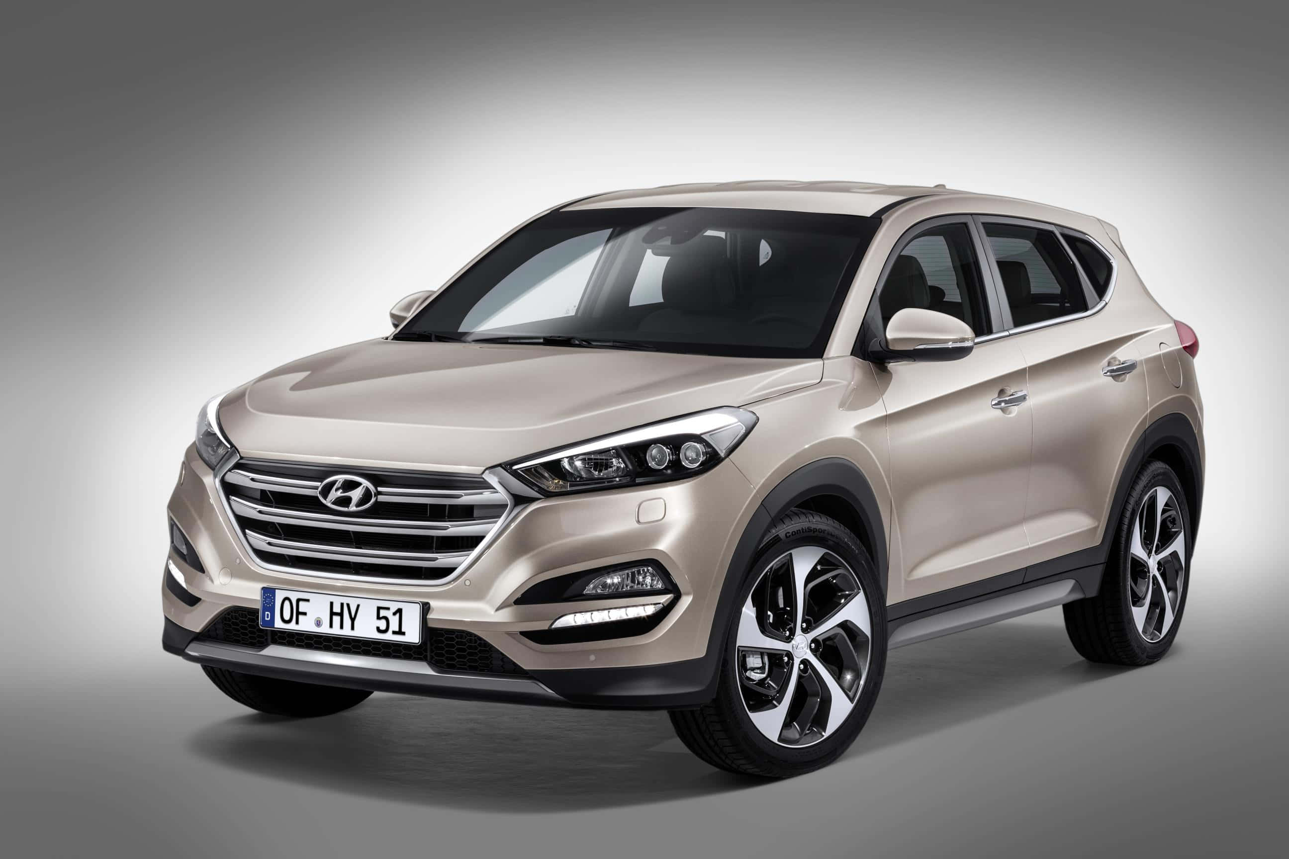 Hyundai 桌布 壁紙 — 在工作室中展示的時尚米色現代 Tucson SUV，柔和漸變燈光凸顯其現代設計和合金輪圈。