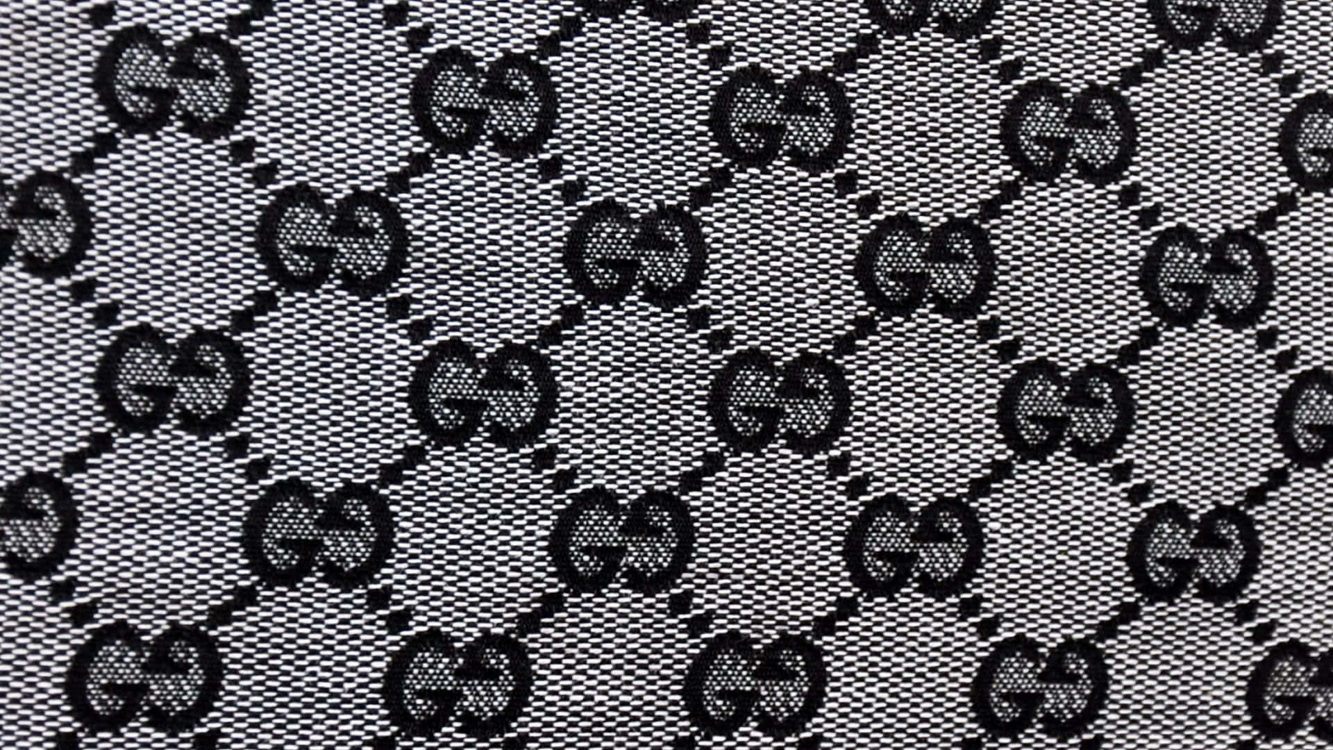 Gucci 桌布 壁紙 — 在帶有斜線縫合的紋理布料上，單色重複的Gucci標誌圖案。