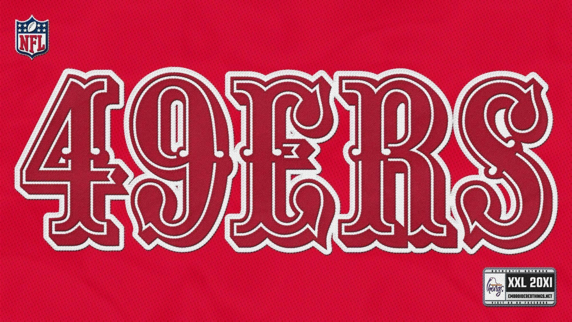 49ers 桌布 壁紙 — 在帶有紋理的布料上，大膽的紅白49ers NFL球衣文字，尺寸標籤可見。