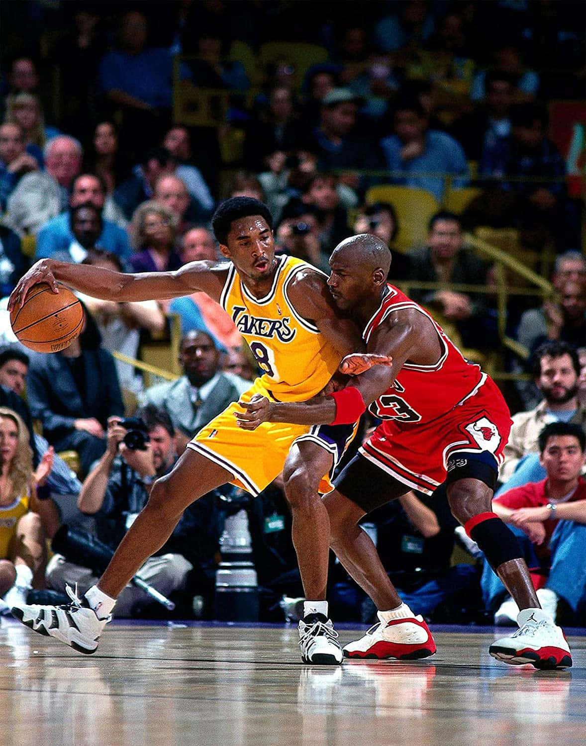 Jordan And Kobe 桌布 壁紙 — 在座無虛席的場館中，黃色湖人隊球員與紅色公牛隊球員之間的動感籃球對決。
