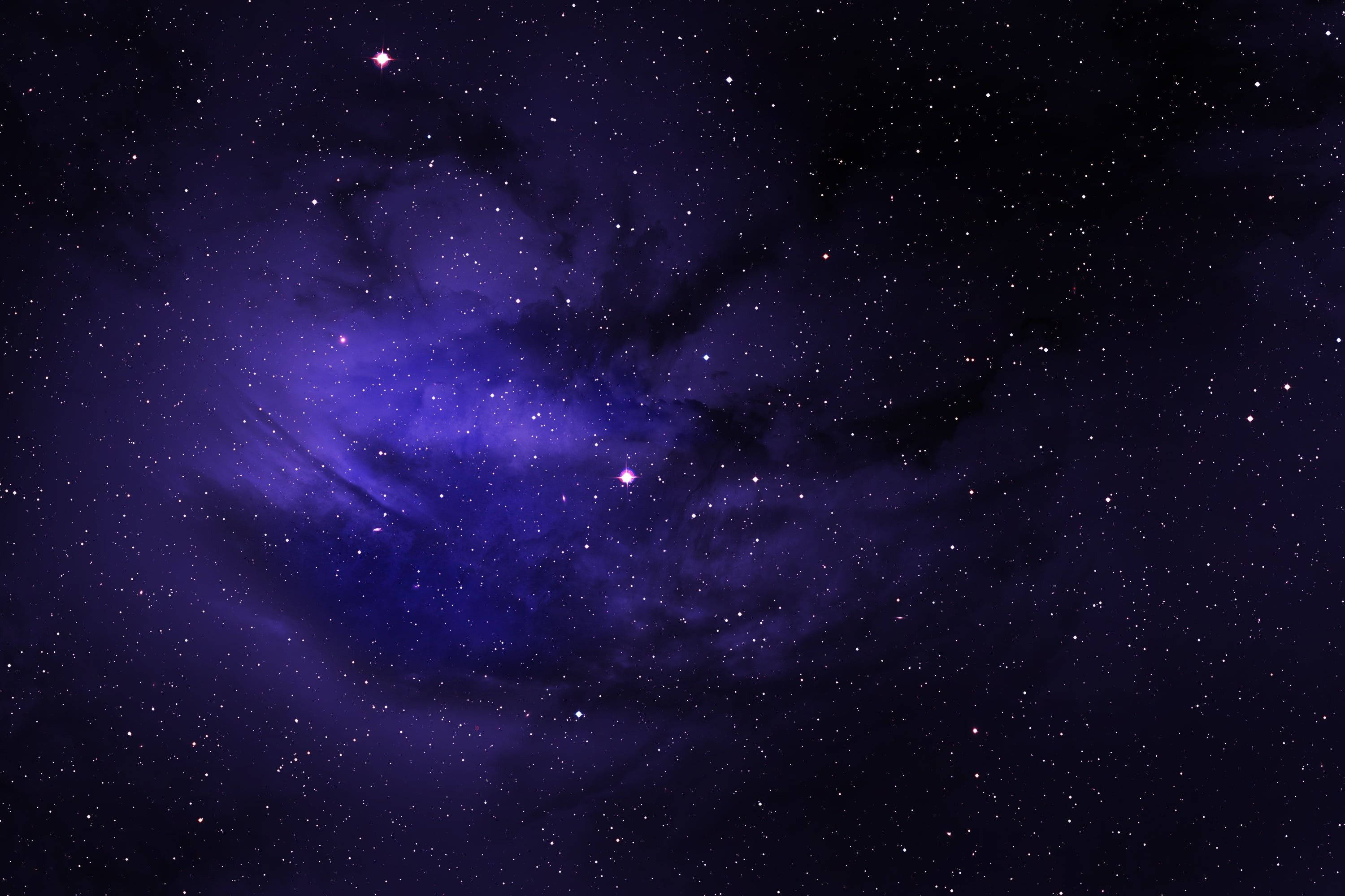 夜空 桌布 壁紙 — 在廣闊夜空無數星辰中閃耀的深紫色星雲的壯麗景色。