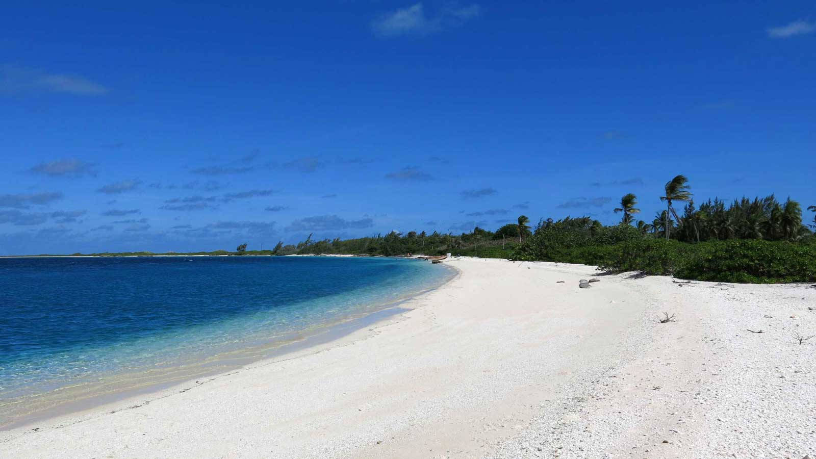 Kiribati 桌布 壁紙 — 在廣闊藍天與零星白雲下，純白沙灘沿著碧綠海水蜿蜒伸展。