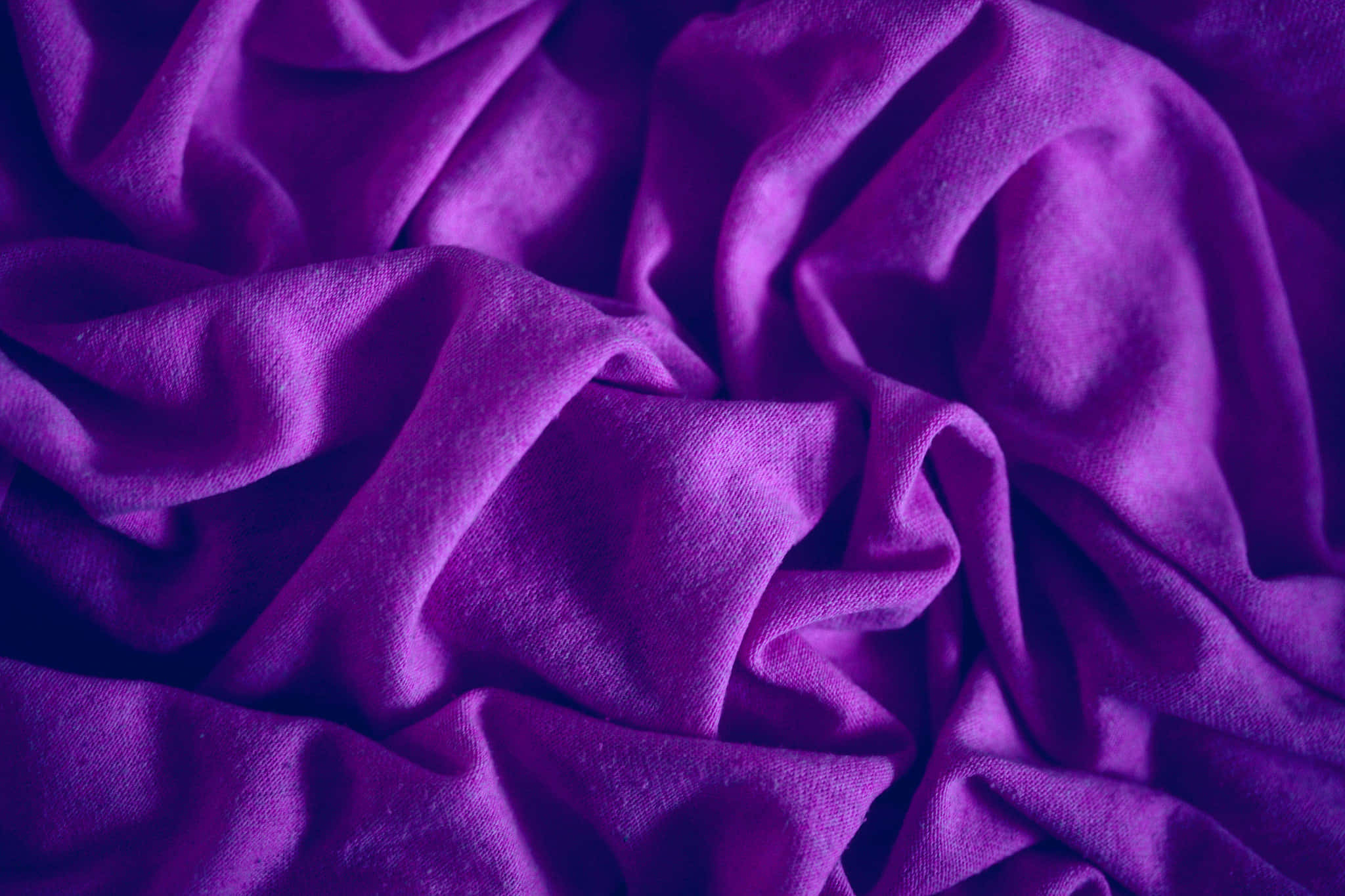 Purple Silk 桌布 壁紙 — 在戲劇性燈光下，帶有深褶皺和柔軟質感的豐富紫色布料。