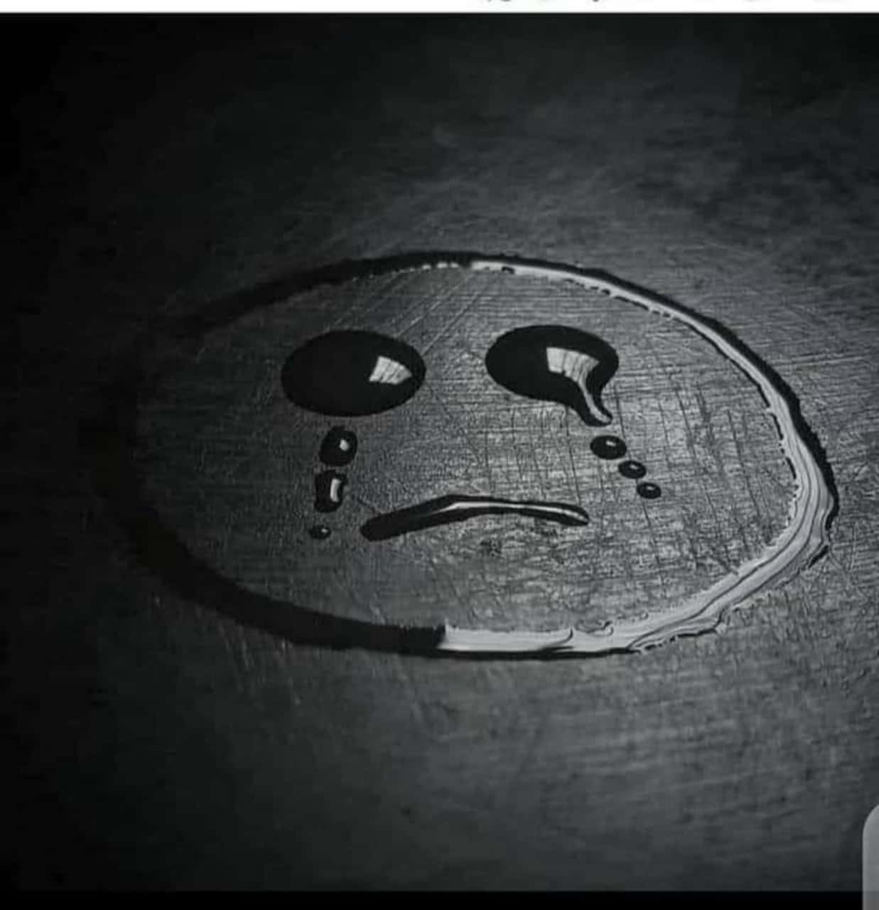 Sad Face 桌布 壁紙 — 在戲劇性燈光下，由水滴在深色紋理表面上形成的悲傷面孔。