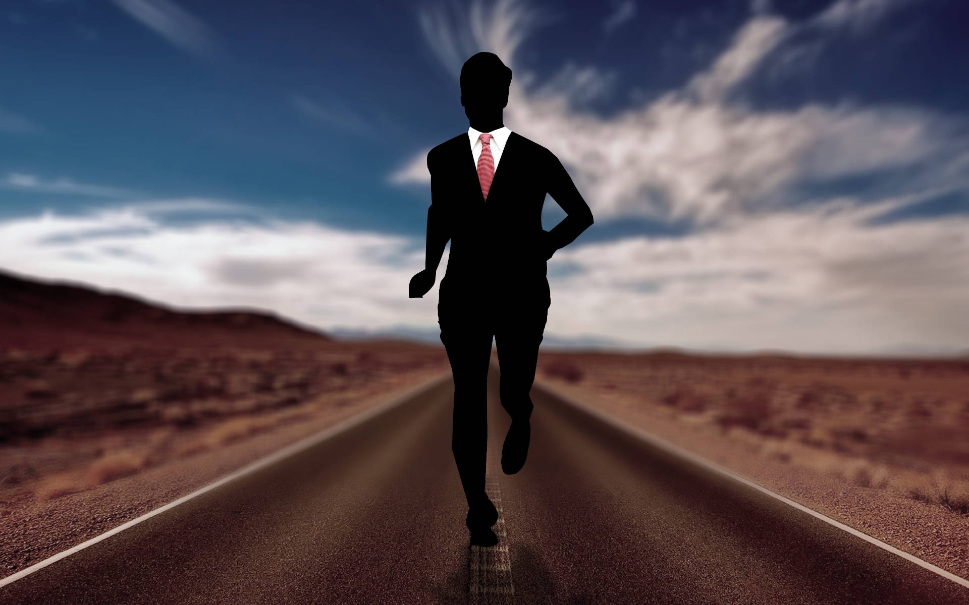 Running 桌布 壁紙 — 在戲劇性的天空下，一名身穿西裝的商人沿沙漠高速公路奔跑的剪影。