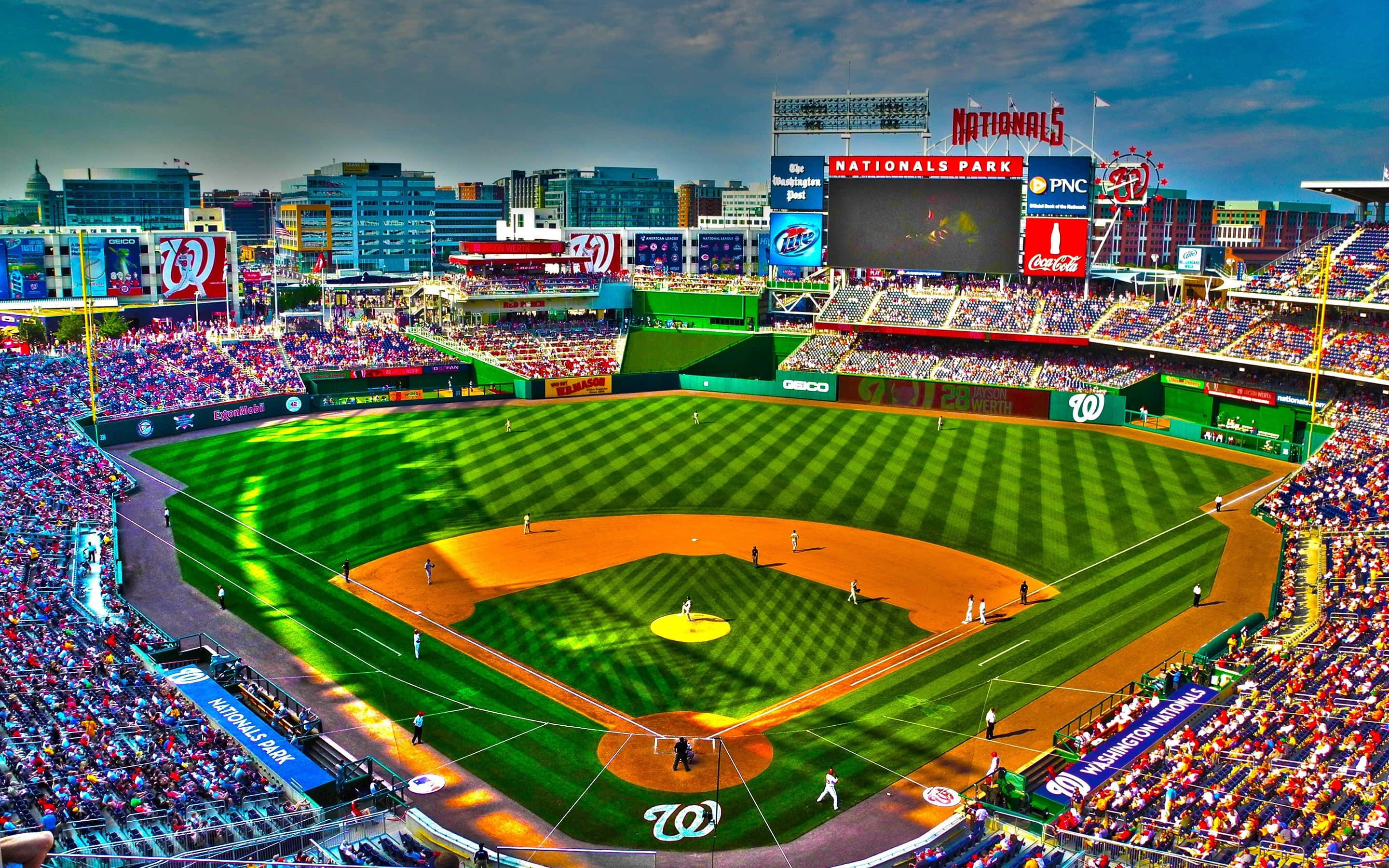 Baseball Stadium 桌布 壁紙 — 在戲劇性的暮色天空下，擠滿球迷的國民公園棒球場鳥瞰圖。