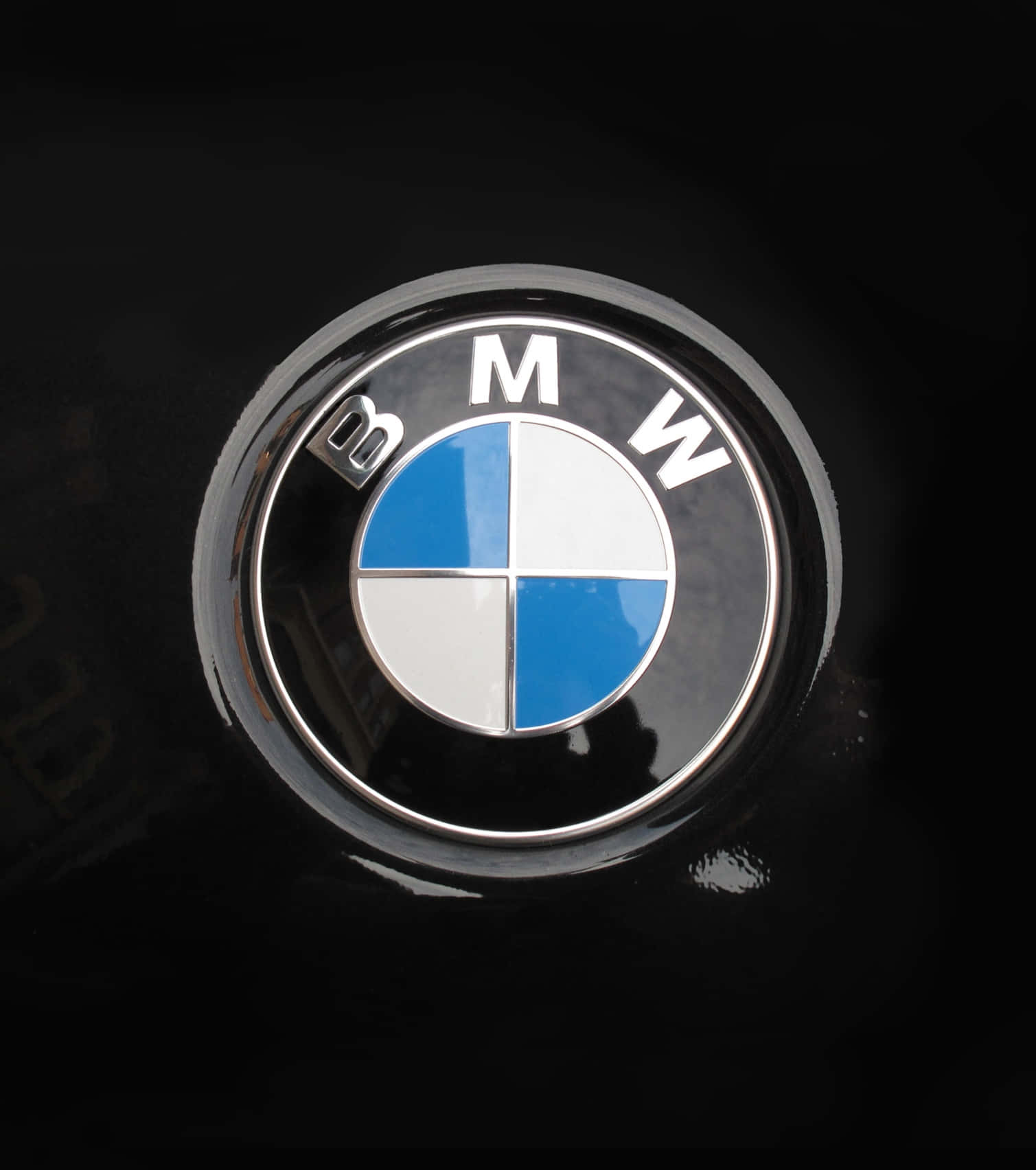 Bmw Logo 桌布 壁紙 — 在攝影棚燈光下，閃亮的BMW標誌徽章特寫，位於光澤黑色汽車引擎蓋上。