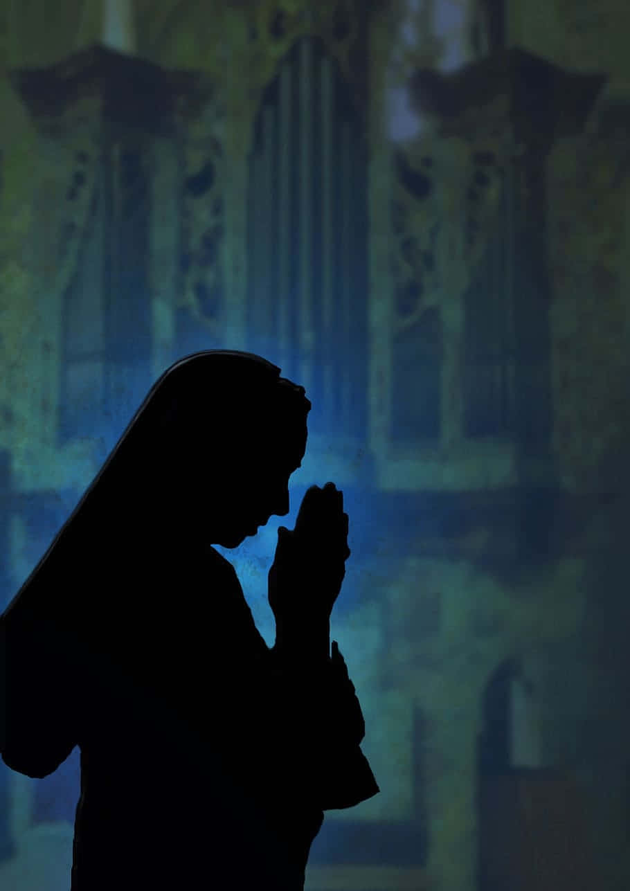 Praying 桌布 壁紙 — 在教堂中祈禱的修女剪影，彩繪玻璃光線在她身後投射出藍色色調。