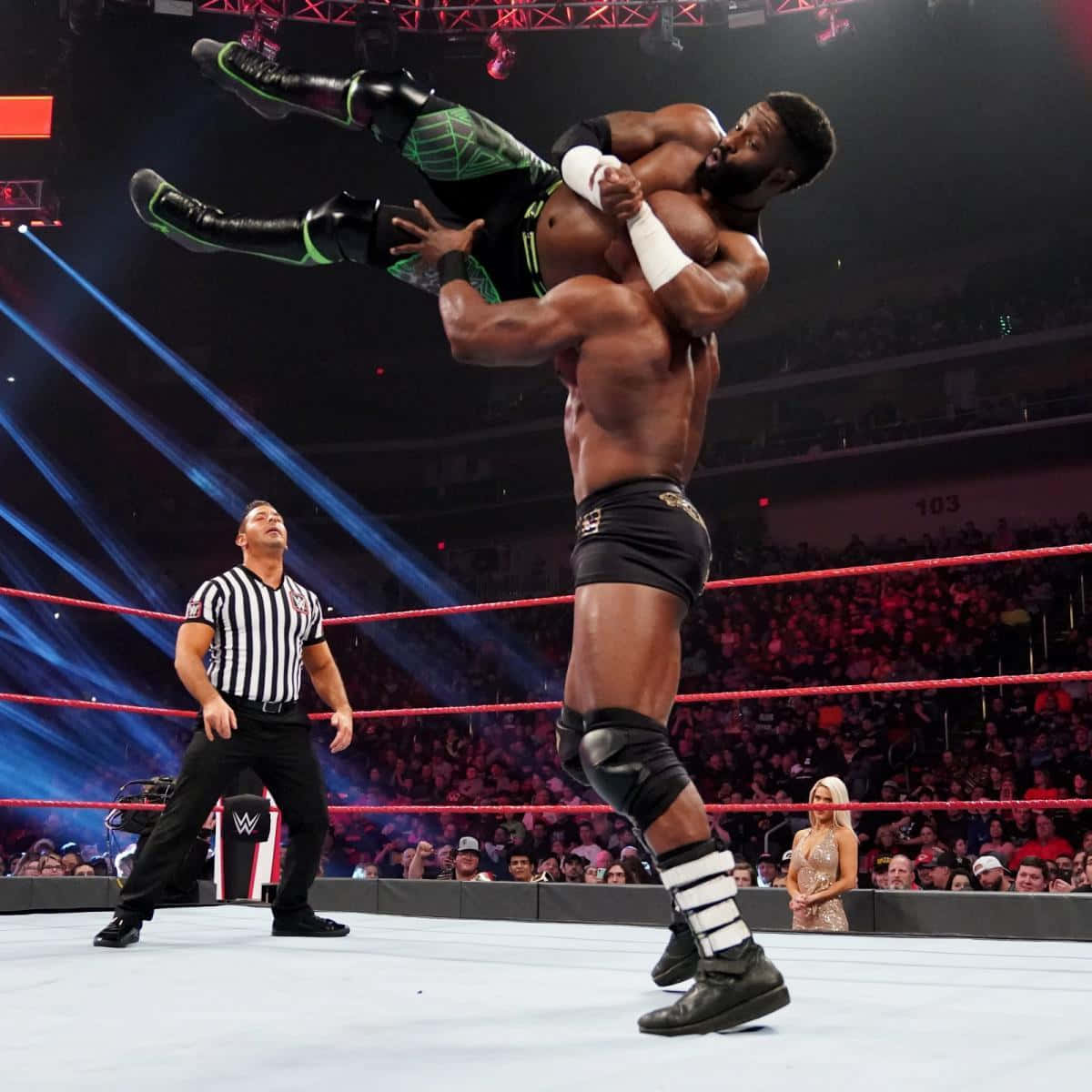WWE 桌布 壁紙 — 在明亮的場館燈光下，一名摔角手將對手高舉過頭頂。